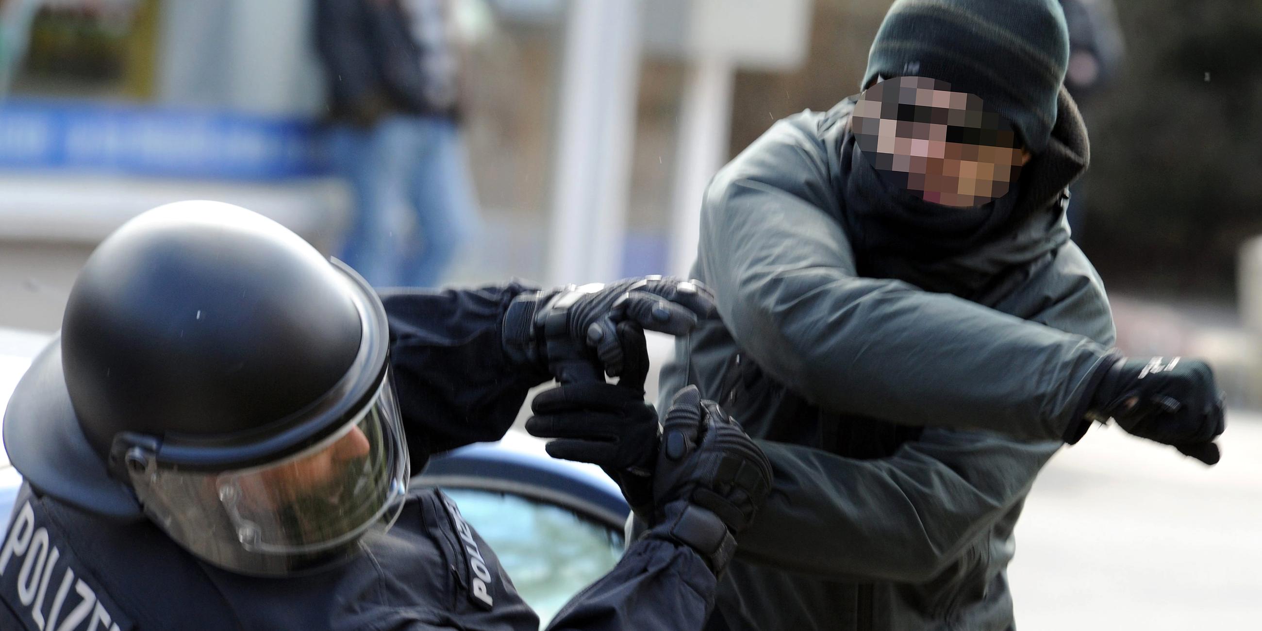 Ein gewalttätiger Demonstrant schlägt einen Polizeibeamten nieder
