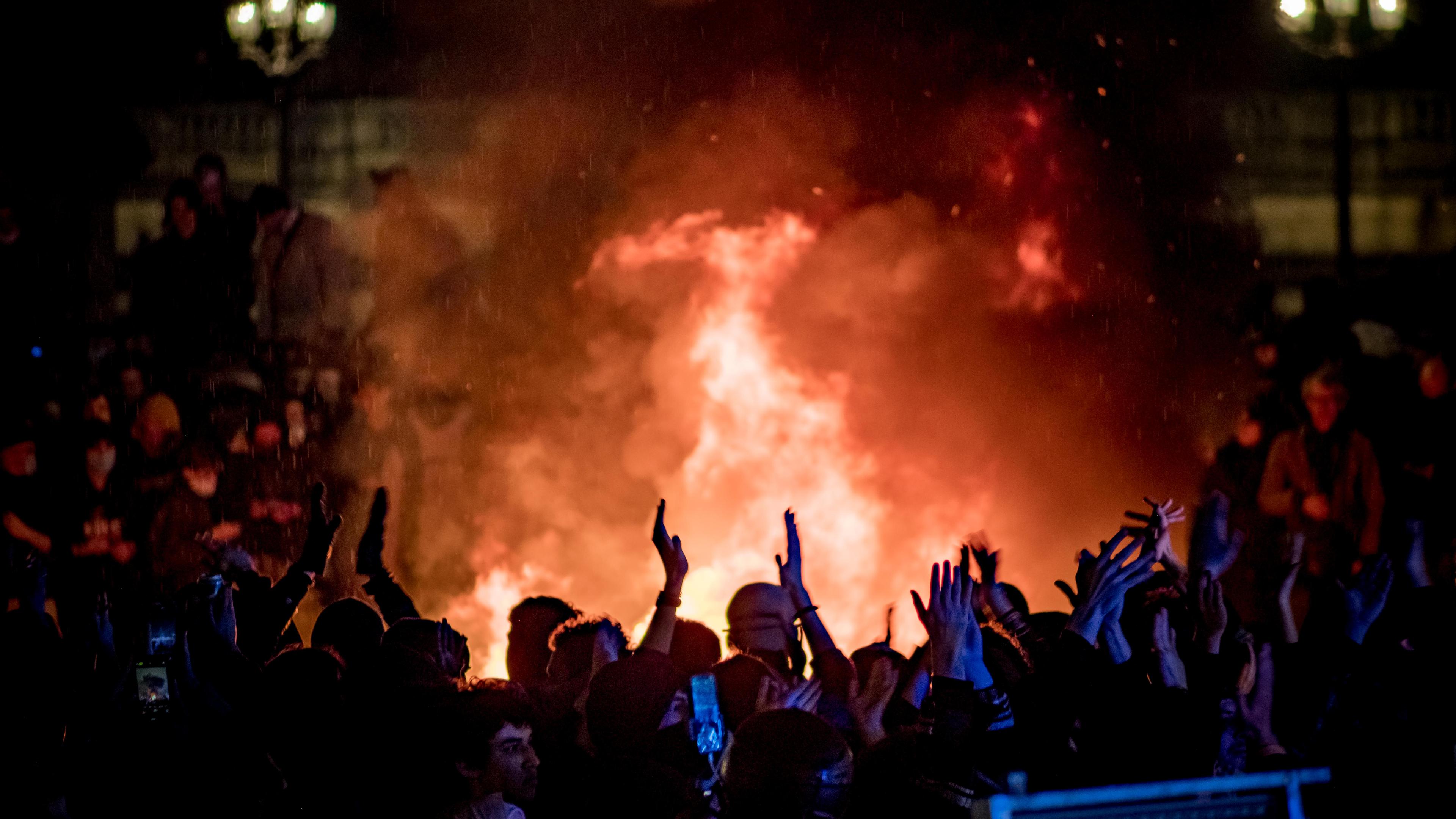 Demonstranten auf dem Place de la Concorde. Im Hintergrund Feuer