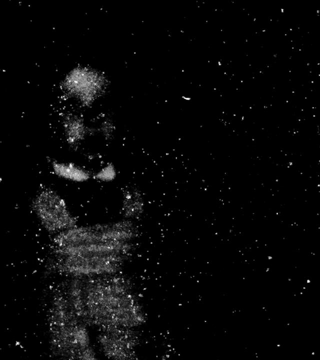 Schemenhafte, aus weißen Partikeln bestehende Figur eines Kindes vor schwarzem Hintergrund