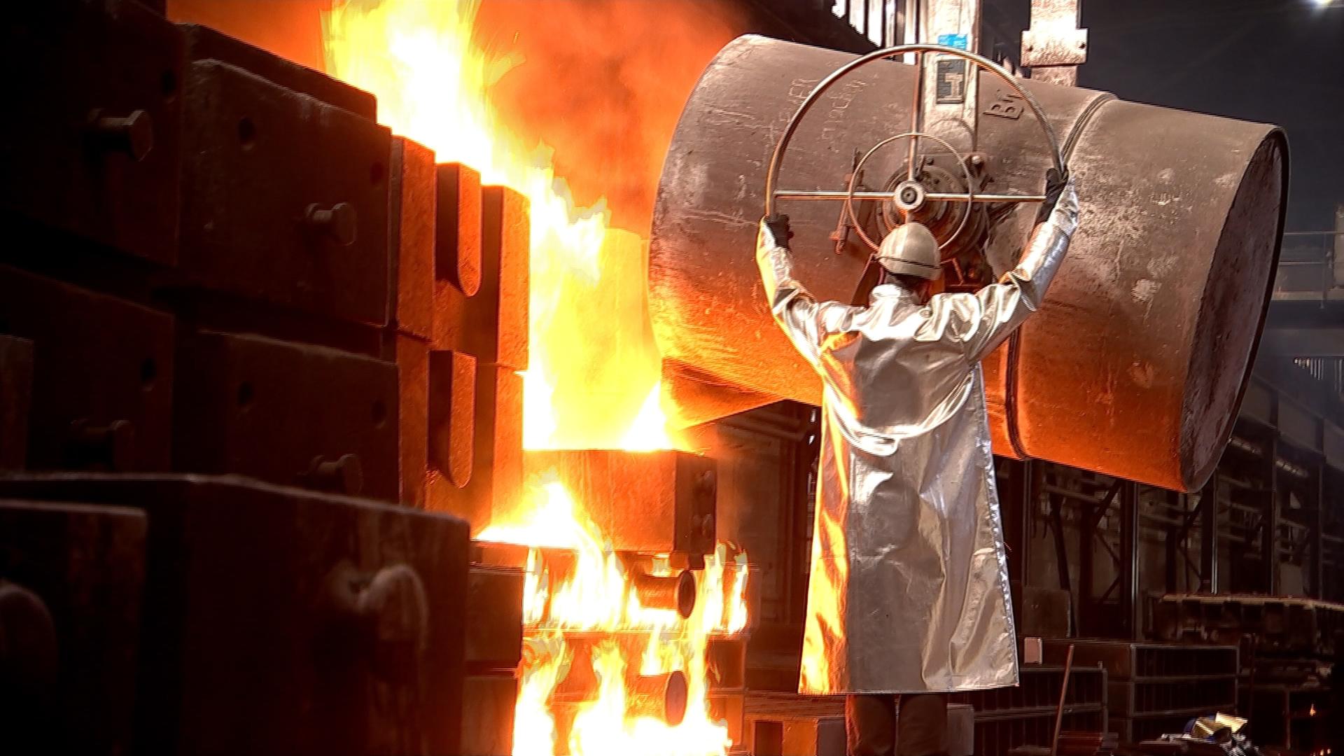 Arbeiter gießt flüssigen Stahl in eine Form