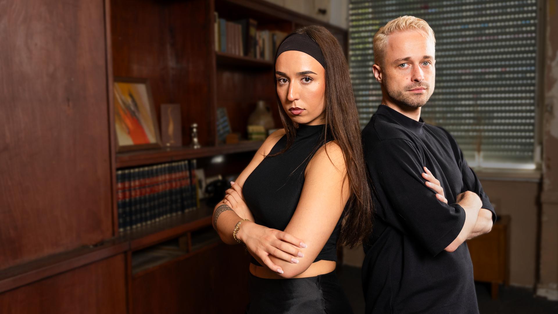 Die Psychologie-Studentin Gina (links) und der KI-Filmemacher Adrian (rechts) stehen Rücken an Rücken rechts im Bild.