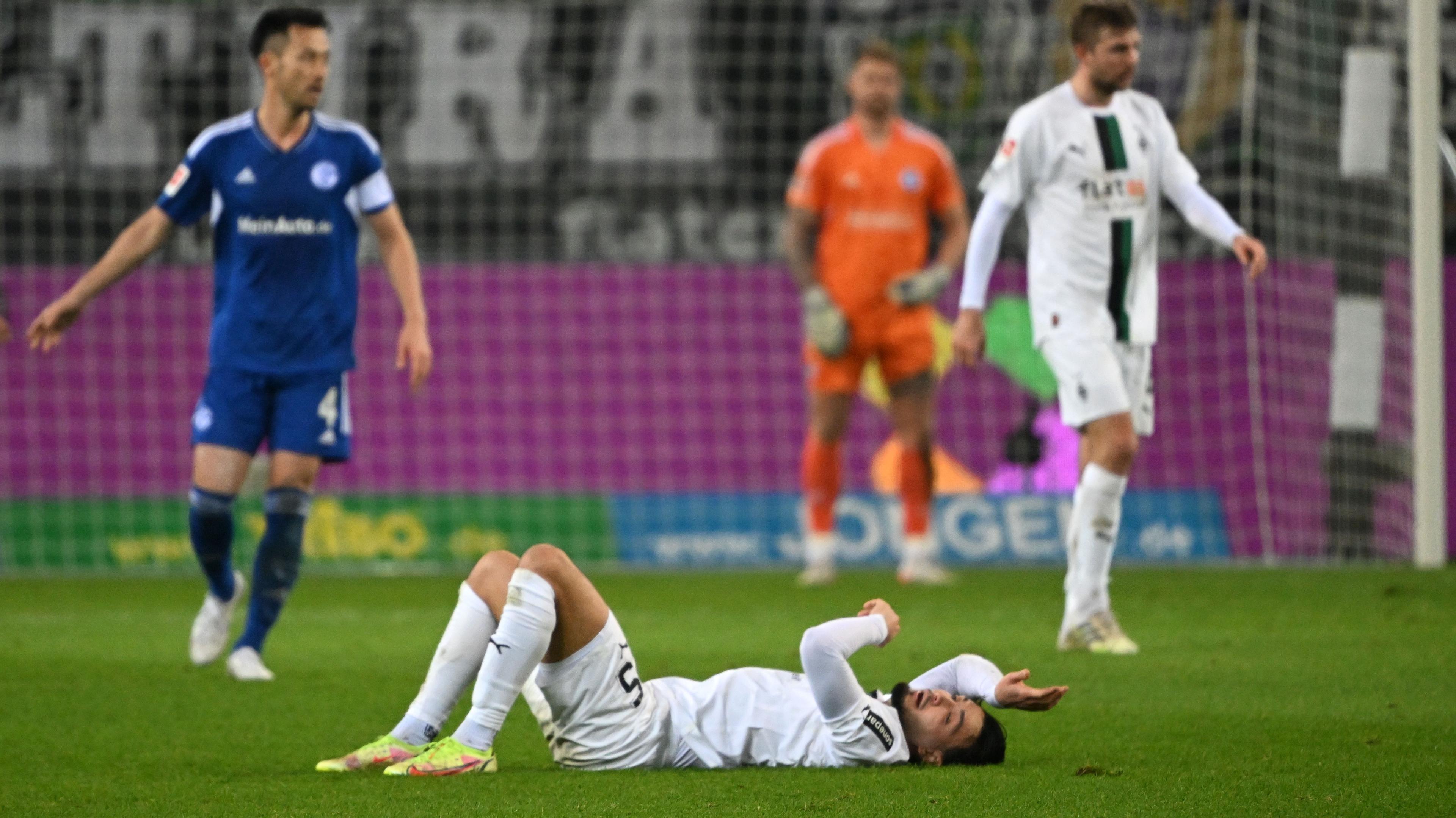 Fußball-Bundesliga, Borussia Mönchengladbach - FC Schalke 04 0:0: Mönchengladbachs Rami Bensebaini liegt nach dem Spiel auf dem Rasen.