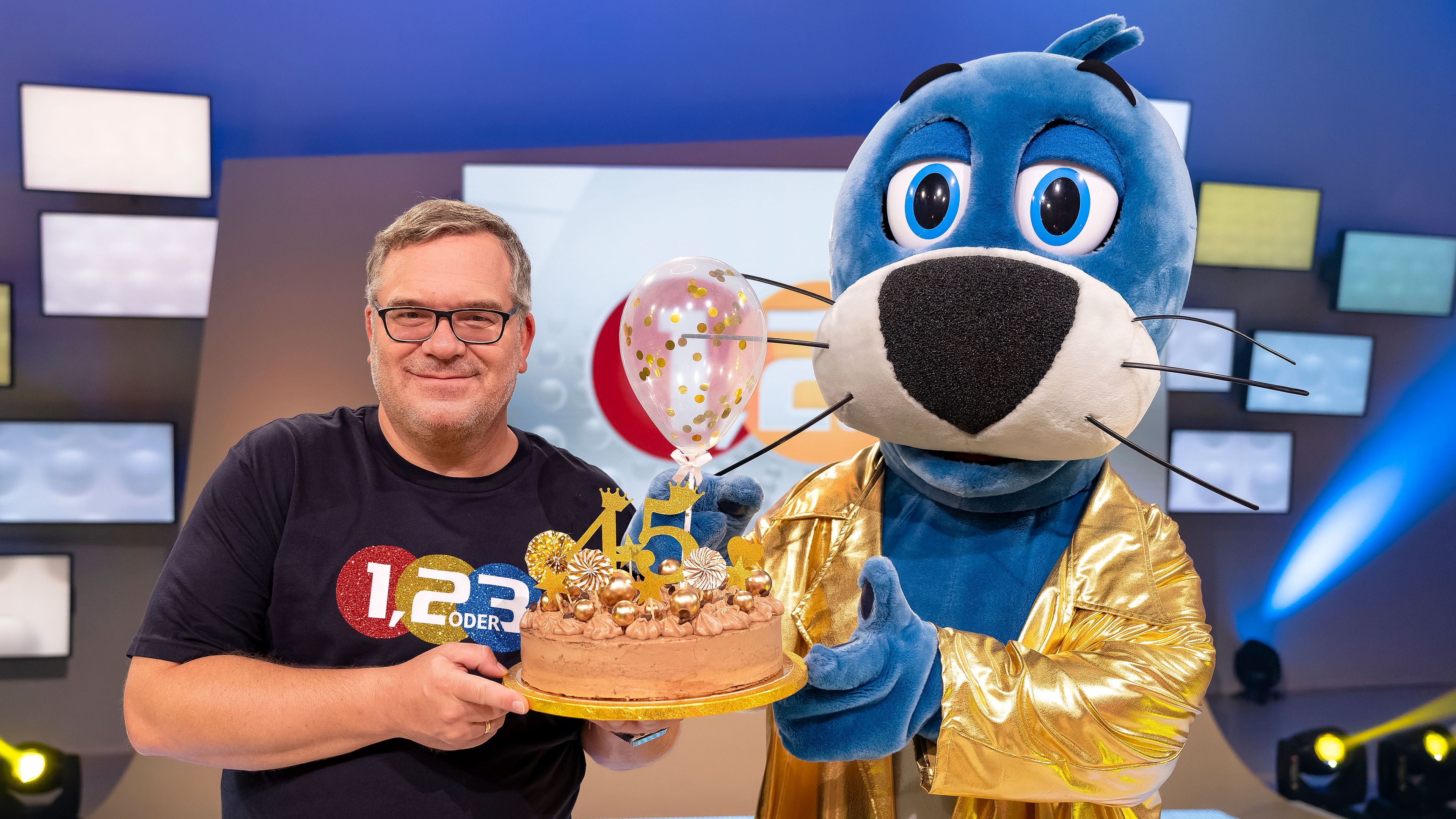 1, 2 oder 3: Moderator Elton und Piet Flosse halten gemeinsam anlässlich des 45. Jubiläums von "1, 2 oder 3" eine Torte in der Hand. 