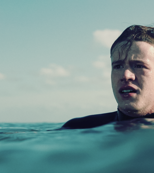 Ein Junge (Jonas Holdenrieder) in einem Neoprenanzug im Meer.