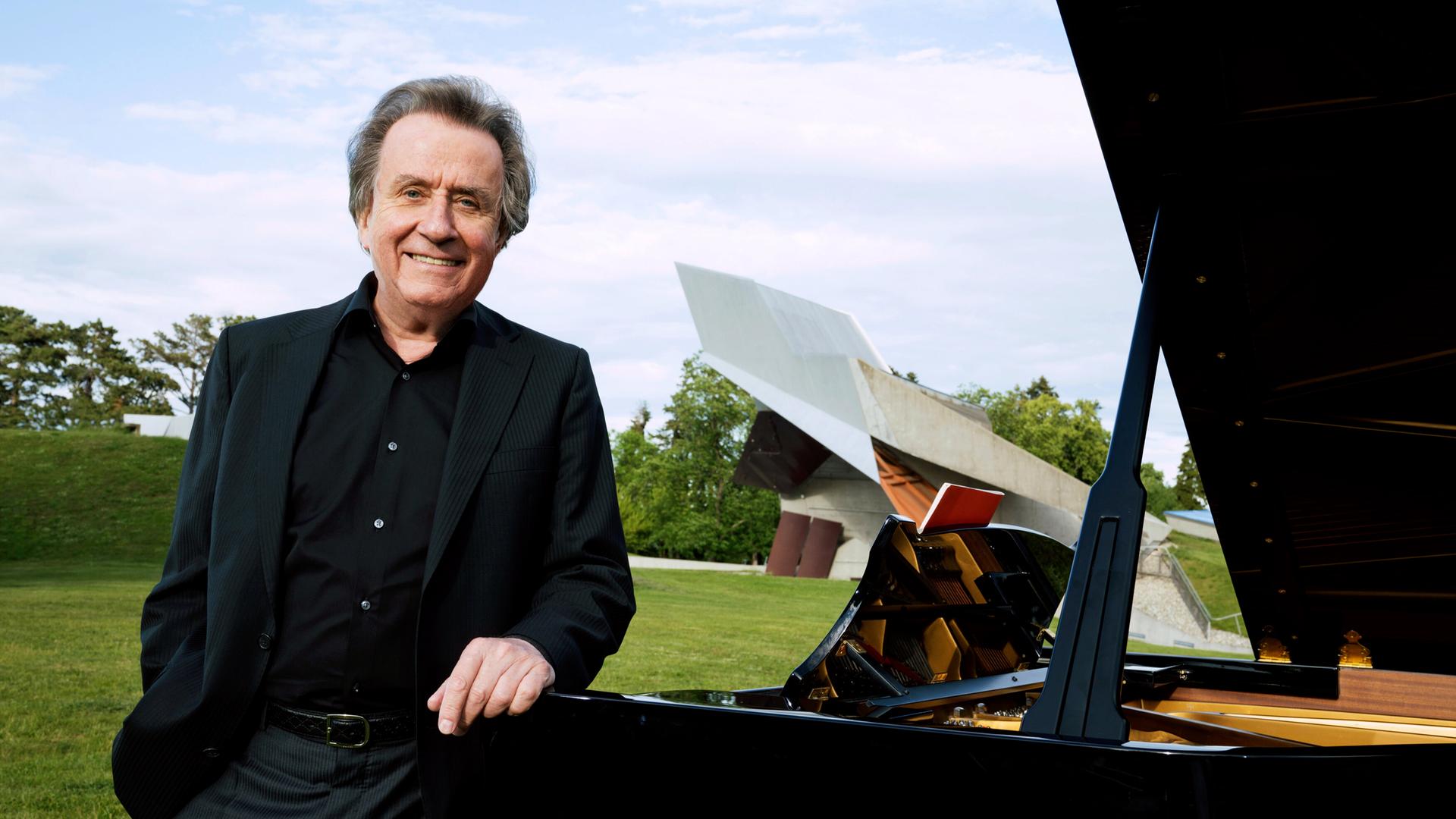 Ein Mann lehnt an einem Flügel, der auf einer Wiese steht