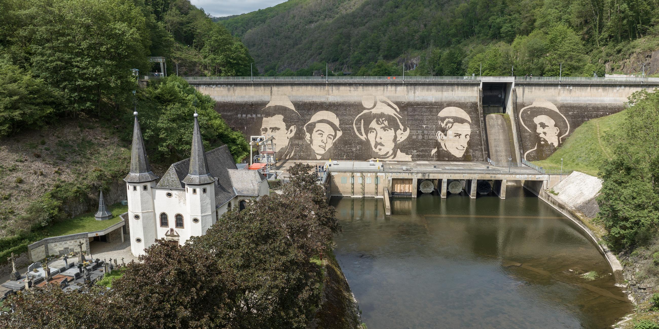 An einer Staumauer im luxemburgischen Vianden prangt das jüngste monumentale Werk des Künstlers Klaus Dauven. Dauven gilt als Pionier des Reverse Graffiti