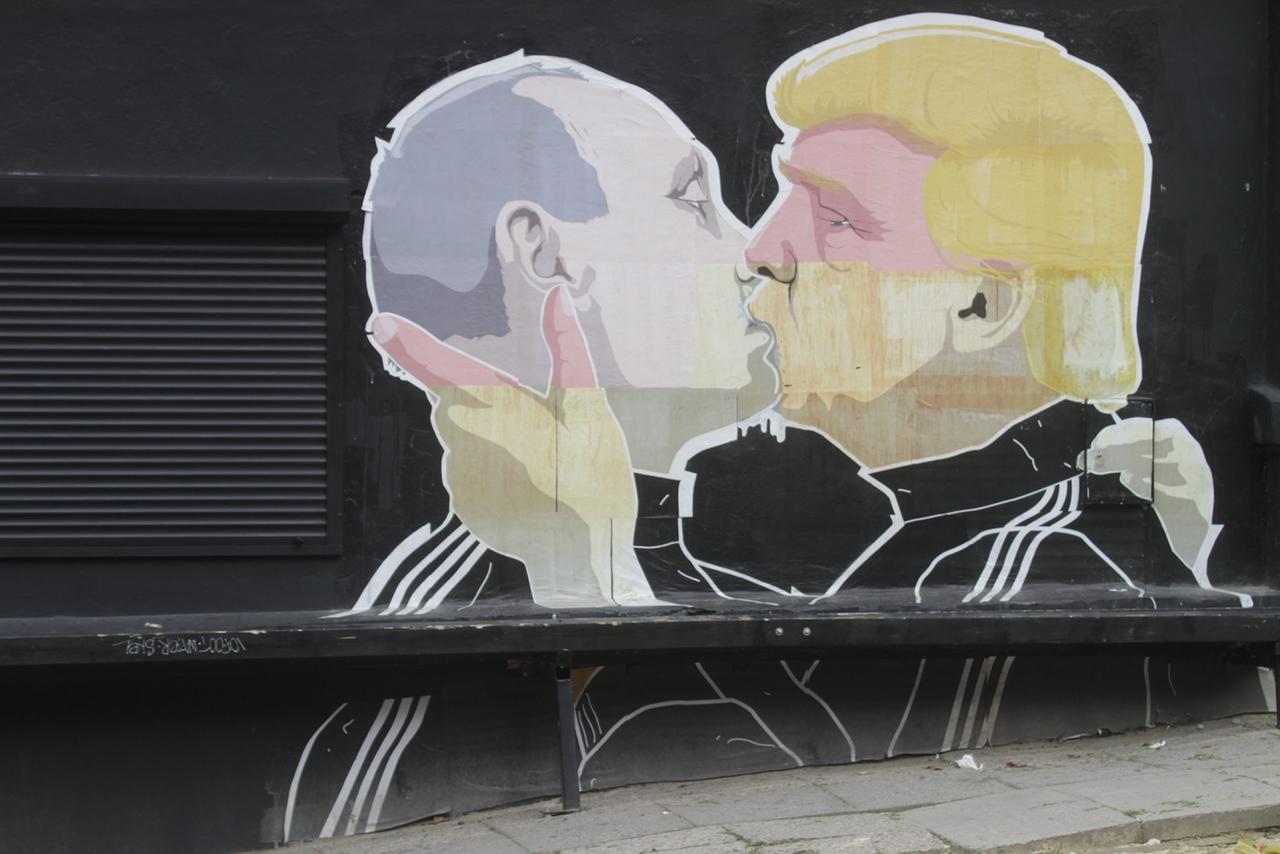 Vue d'une fresque murale de graffitis de l'artiste lituanien Mindaugas Bonanu représentant le candidat républicain à la présidentielle américaine Donald Trump (à droite) embrassant le président russe Vladimir Poutine sur le mur d'un restaurant barbecue Keule Ruke à Vilnius, en Lituanie, le 4 août 2016. 