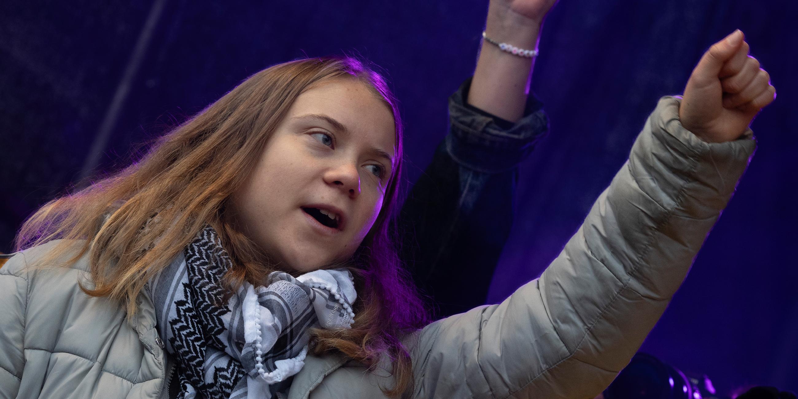 Greta Thunberg streckt bei einer Kundgebung am 12.11.2023 in Amsterdam eine Faust hoch.