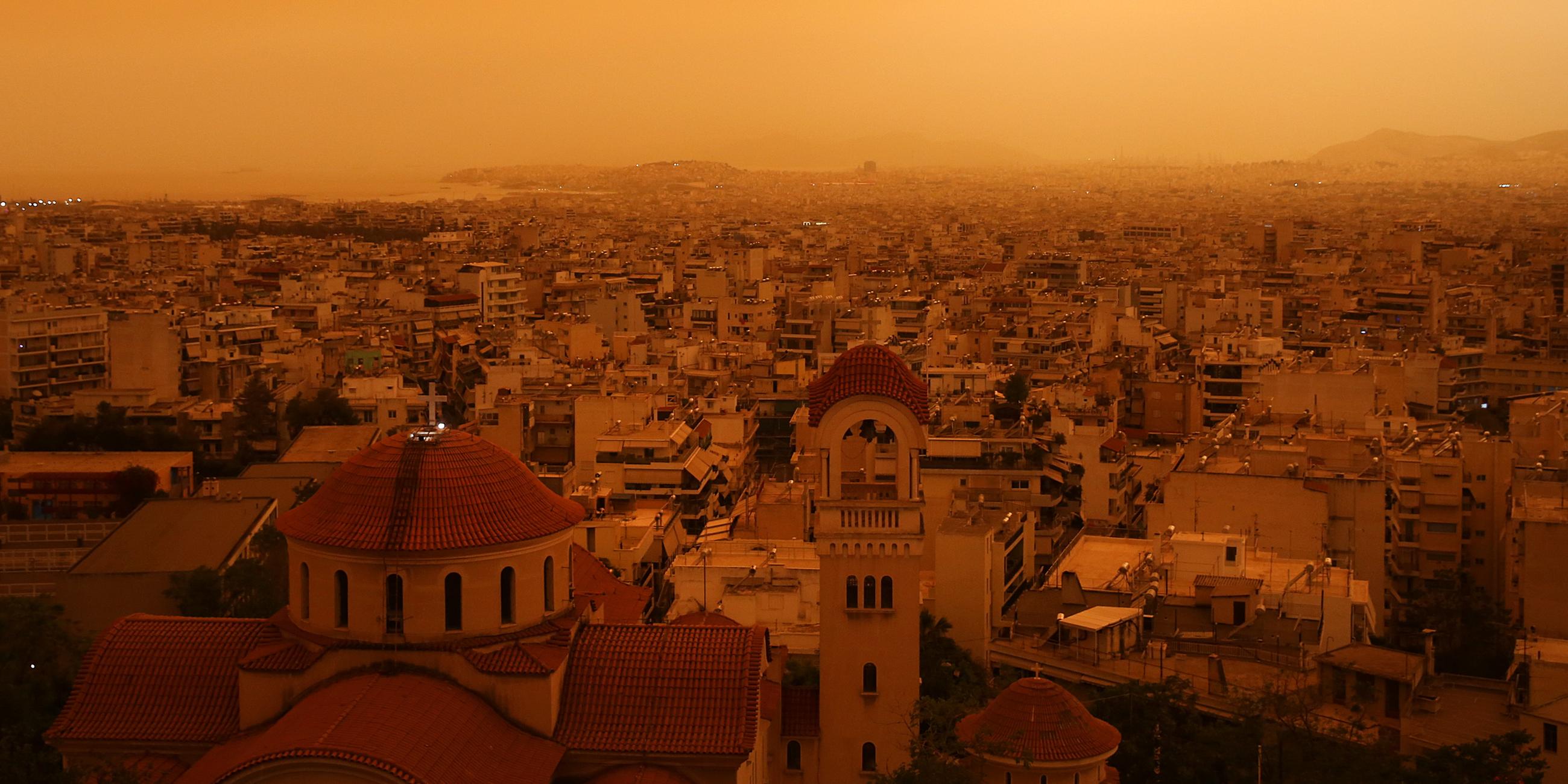 In Athen hat aus Afrika kommender Wüstenstaub den Himmel orange gefärbt