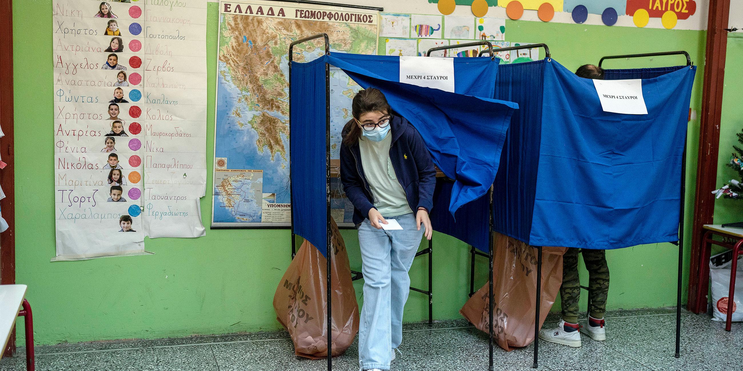Junge Frau kommt aus der Wahlkabine in Athen, Griechenland