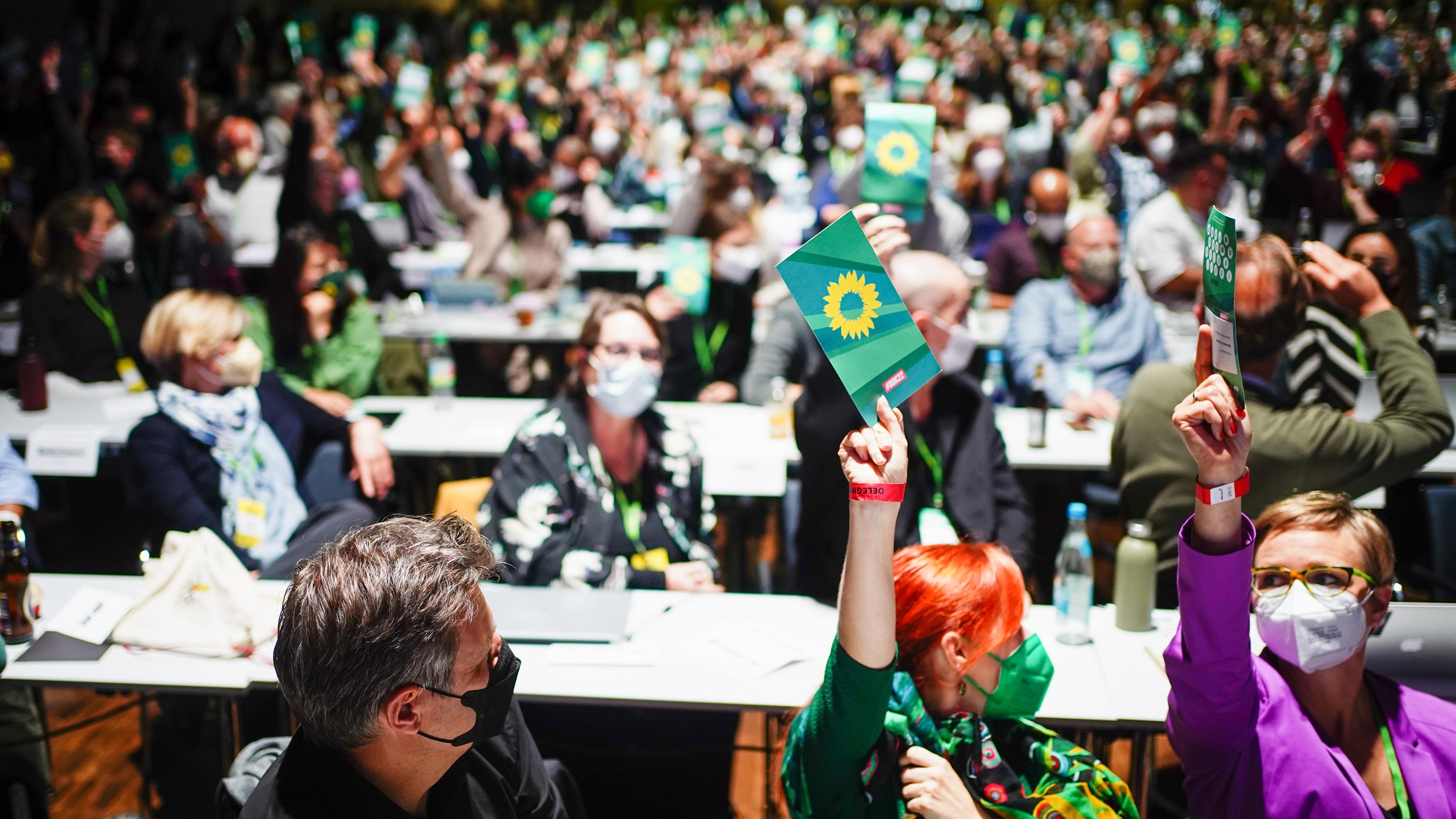 Delegierte halten auf dem Grünen-Parteitag in Bonn Stimmzettel hoch