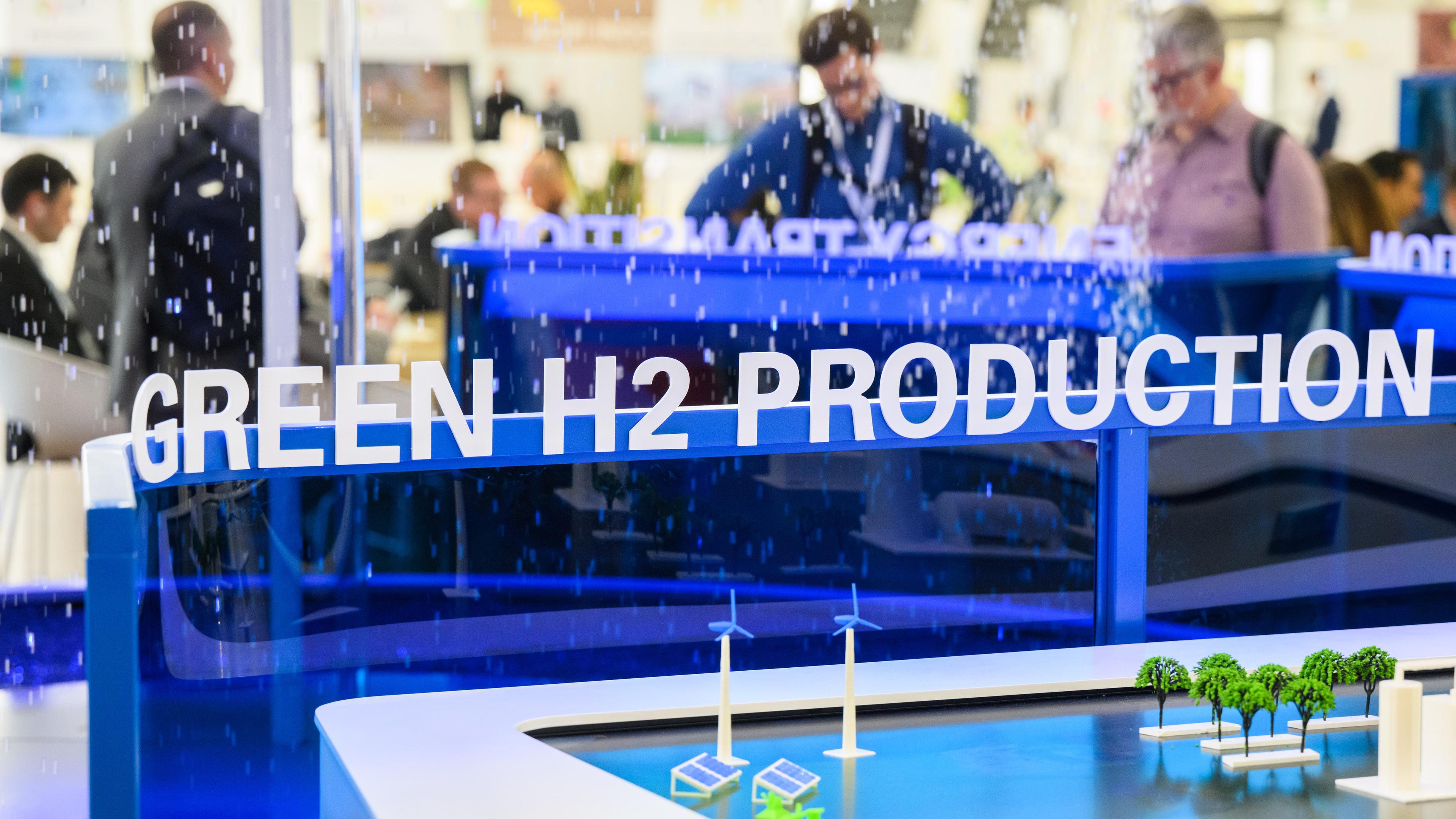 Der Schriftzug ·Green H2 Production· (deutsch: Produktion von grünem Wasserstoff) steht bei der Industriemesse Hannover Messe an einem Messestand von Brasilien am 20.04.2023