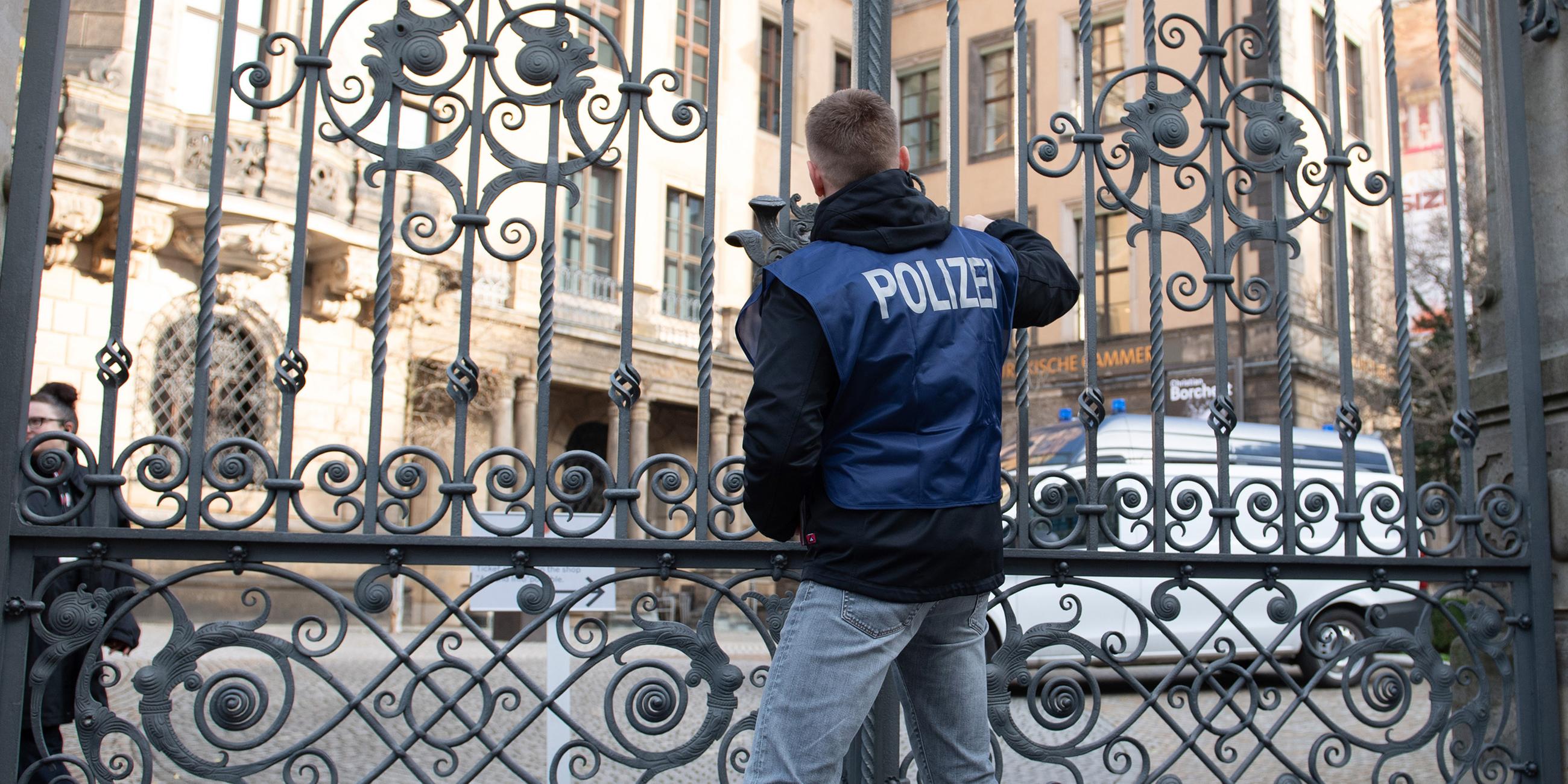 Ein Polizist verschließt vor dem Residenzschloss ein Tor