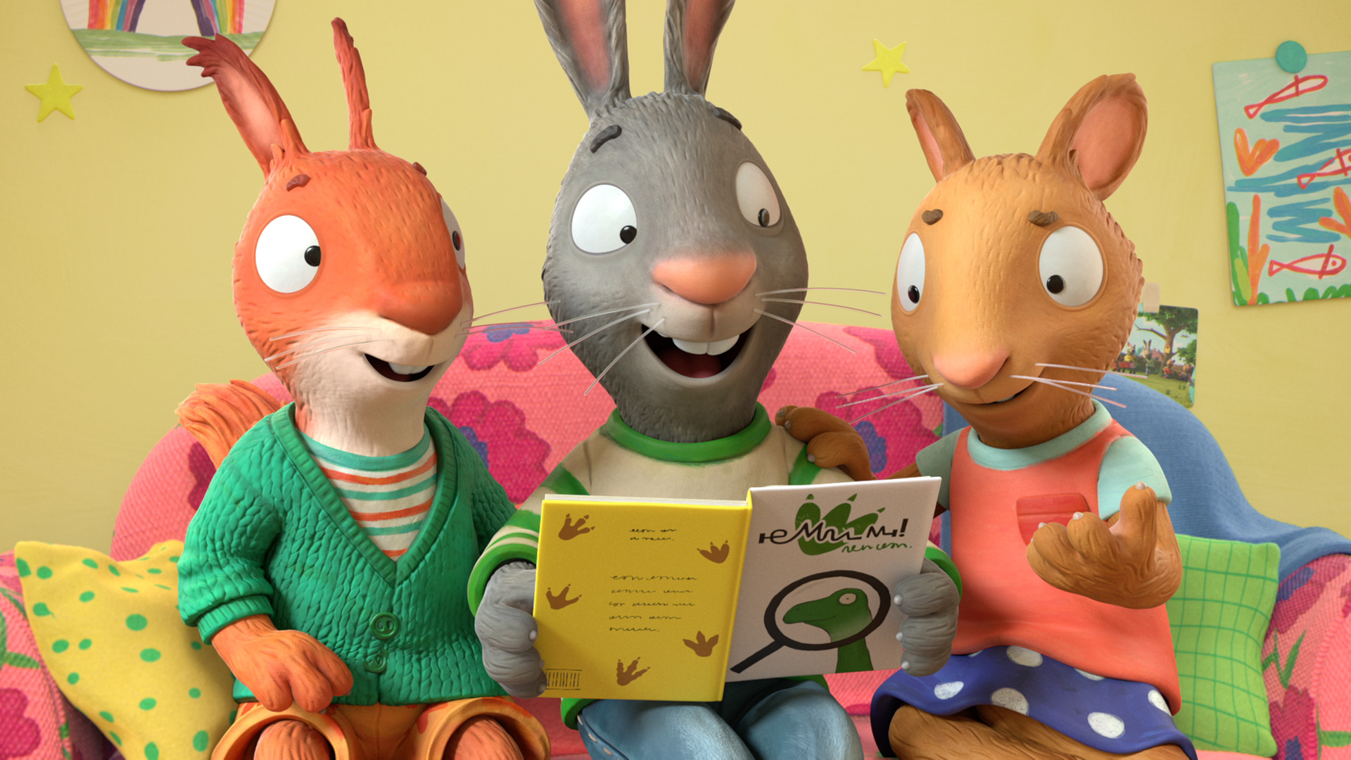 Jamila, das Eichhörnchen, Pip, das Kaninchen und Posy, die Maus, sitzen nebeneinander auf einer pinkfarbenen Couch mit rot-blauen Blumen. Pip hält ein geöffnetes Dino-Buch in beiden Händen.  Alle drei schauen lächelnd in das Buch. Posy hat ihre rechte Hand auf Pips linker Schulter liegen. Ihre linke Hand zeigt geöffnet nach vorne. Neben Jamila liegt ein gelbes Kissen mit grünen Punkten und neben Posy ein grünes Kissen mit Karomuster. An der gelben Wand befinden sich verschiedene Bilder.