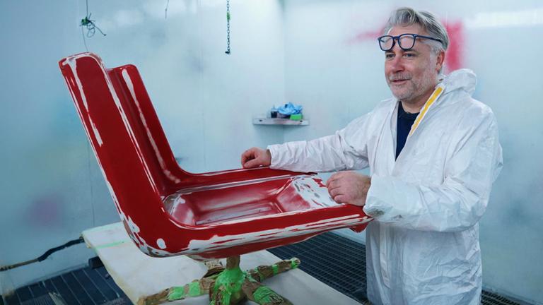 Händler Jan Cizek arbeitet an zwei roten Sesseln