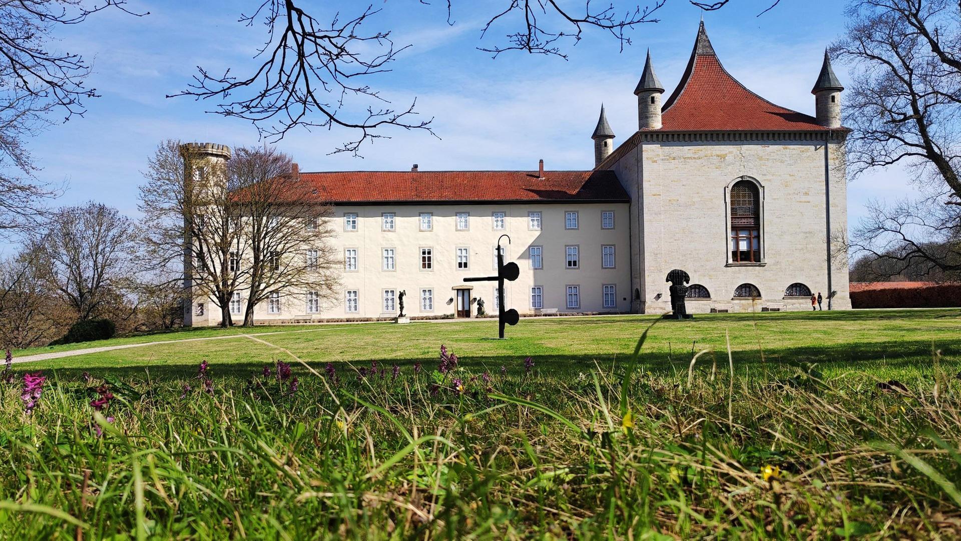 Ein kleines Schloss und der gepflegte Rasen davor.