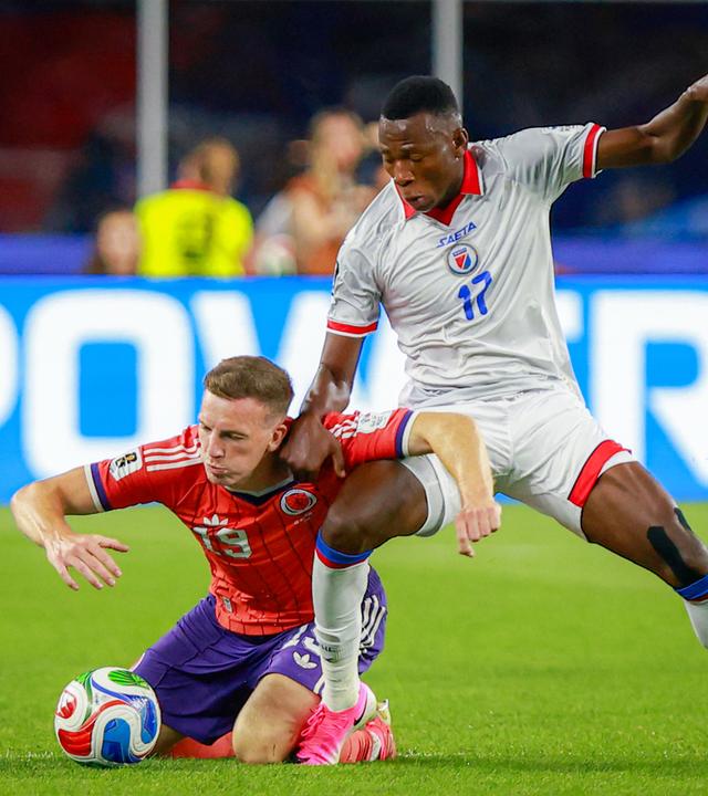 Der schottische Nationalspieler Lewis Ferguson geht im Zweikampf mit dem haitianischen Nationalspieler Danley Jean Jacques zu Boden