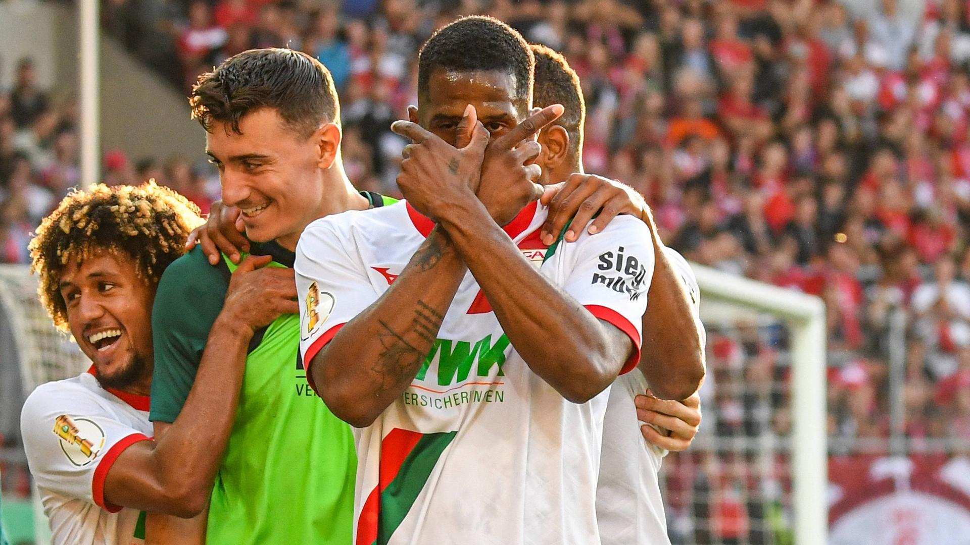 DFB-Pokal: Halle gegen Augsburg. Samuel Essende vom FC Augsburg kreuzt die Finger vor dem Gesicht beim Torjubel.