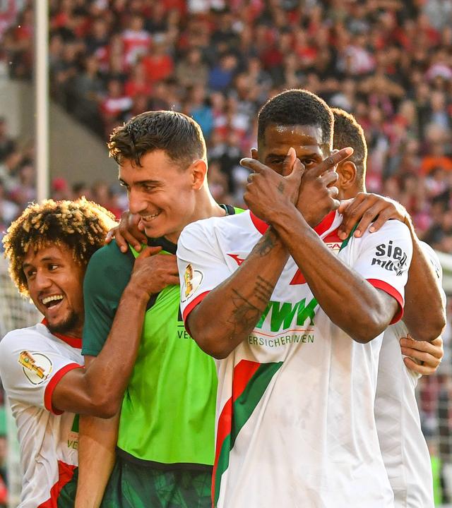 DFB-Pokal: Halle gegen Augsburg. Samuel Essende vom FC Augsburg kreuzt die Finger vor dem Gesicht beim Torjubel.