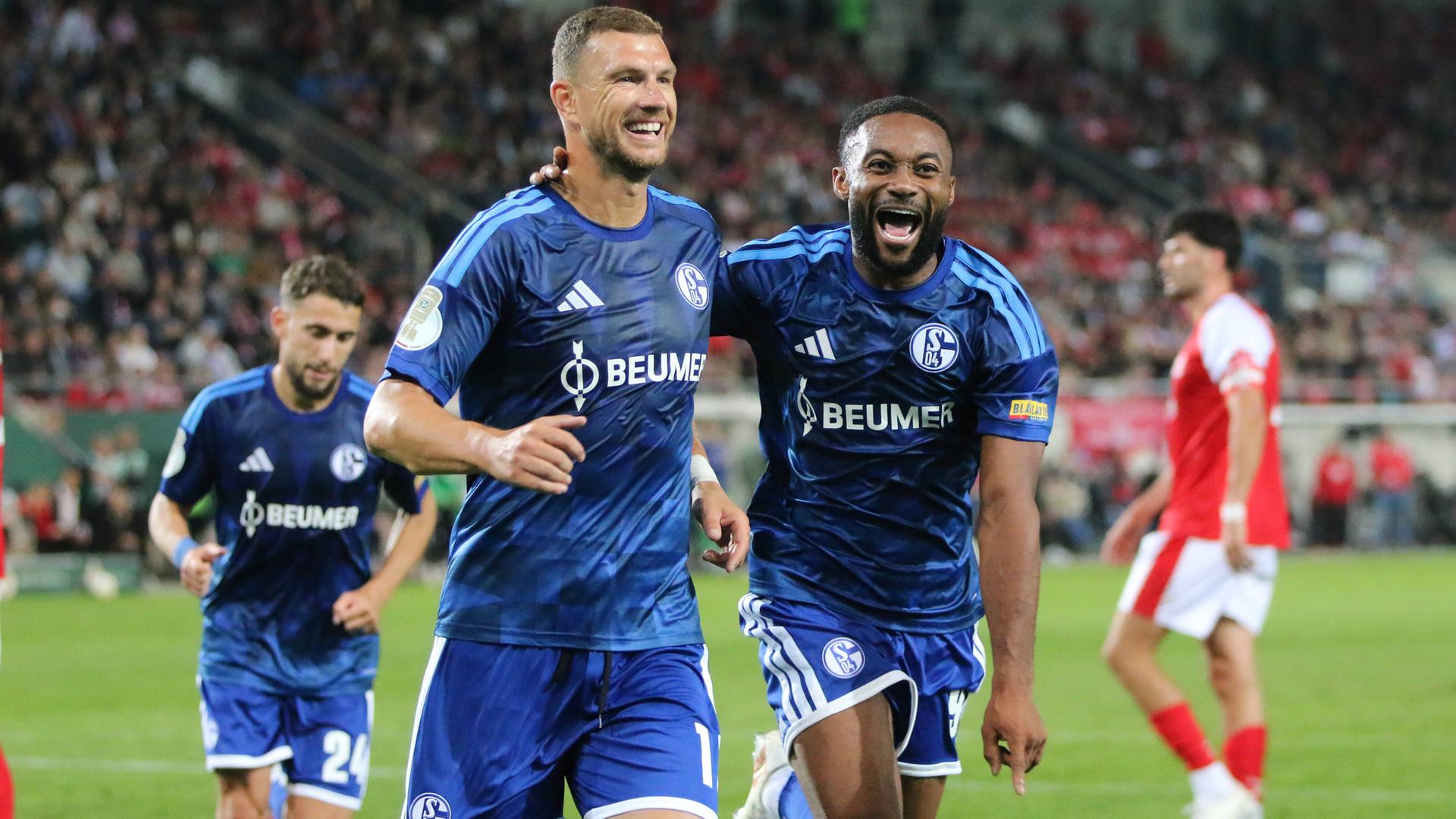 Edin Dzeko (Schalke) und Moussa Sylla (Schalke) jubeln. 