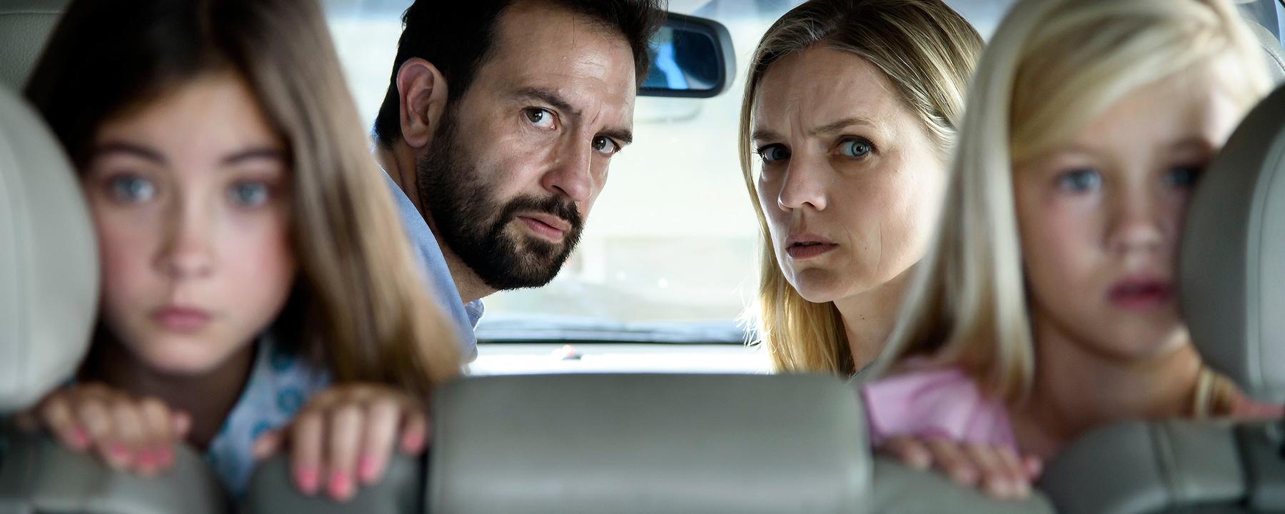 Hans (Jeroen Spitzenberger) und Diana (Anniek Pheifer) befinden sich rückwärtsgewandt im Inneren ihres Wagens und blicken skeptisch in Richtung der Heckscheibe. Milou (Roosmarijn van der Hoek) und Robine (Liz Vergeer) knien ebenfalls verkehrt herum auf dem Rücksitz und sehen erstaunt durch das Autofenster.