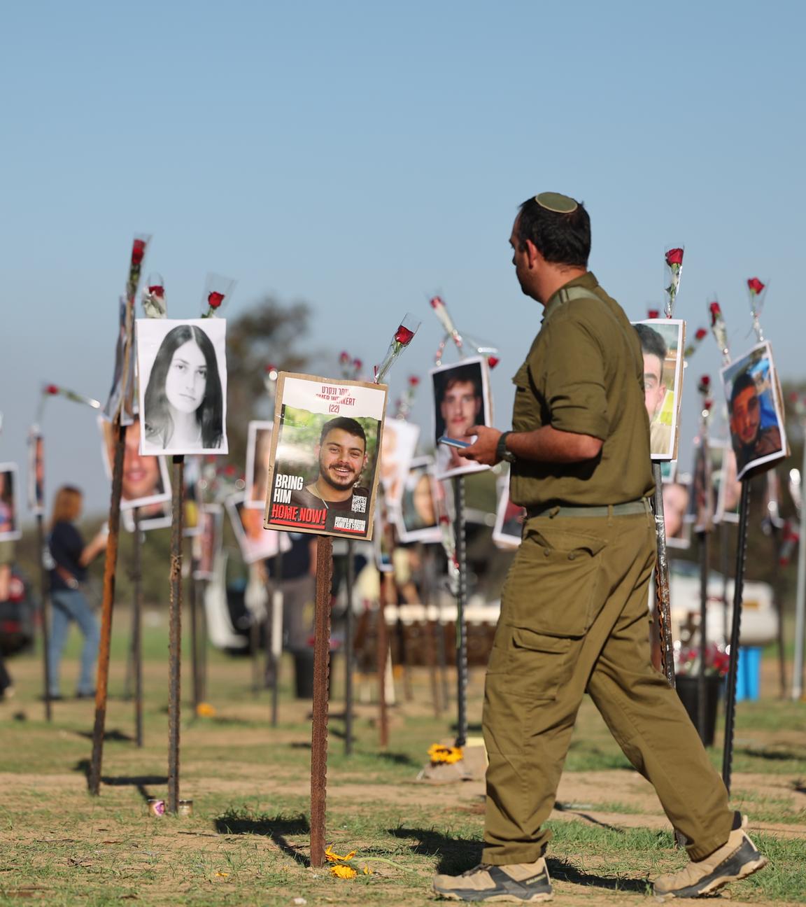 Ein israelischer Soldat sieht sich die Bilder der zahlreichen Opfer nach dem Angriff der Hamas am 7. Oktober beim Nova-Musikfestival an.
