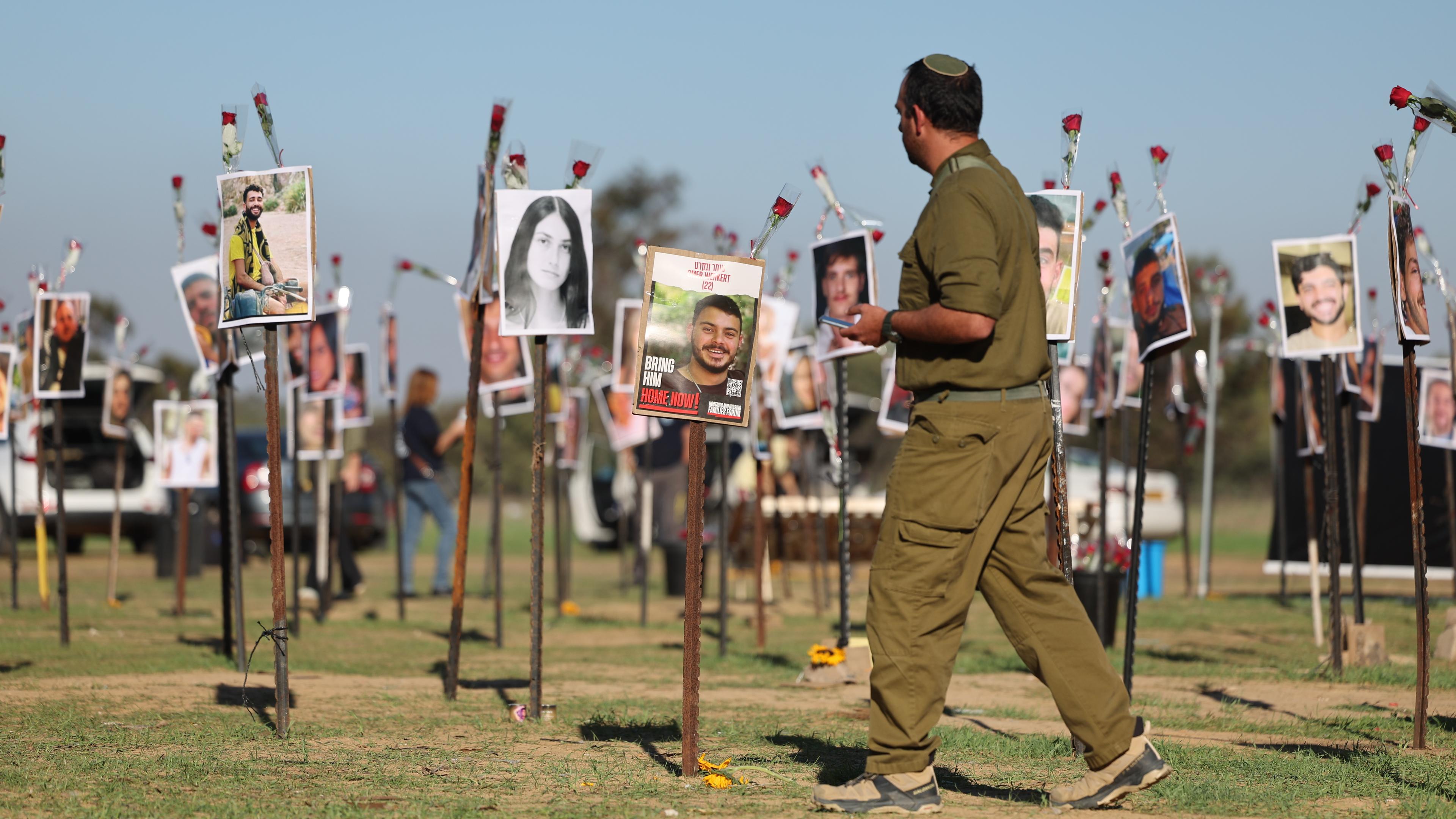 Ein israelischer Soldat sieht sich die Bilder der zahlreichen Opfer nach dem Angriff der Hamas am 7. Oktober beim Nova-Musikfestival an.