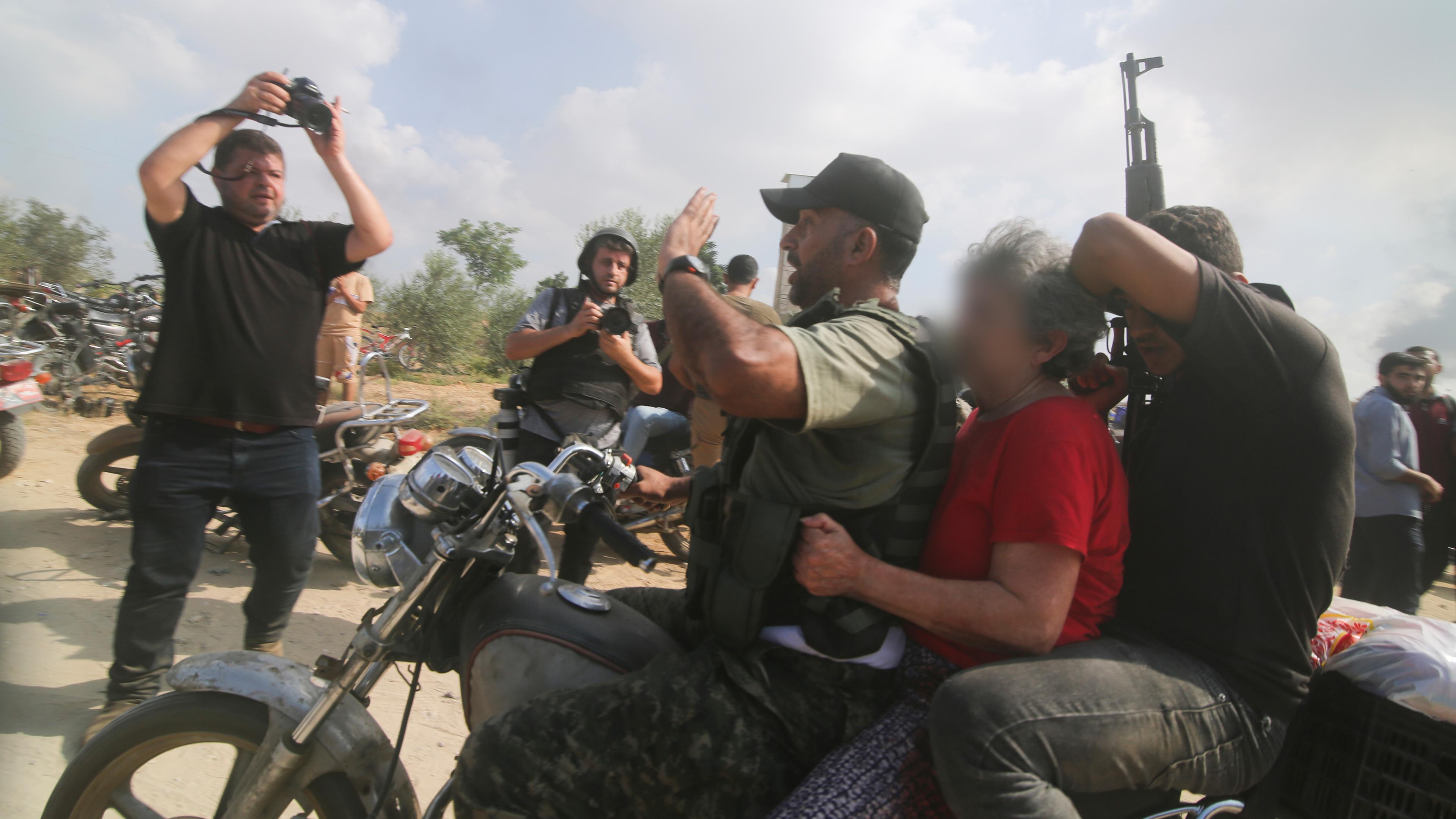Israel, Kibbutz Kfar Azza: Anhänger der Hamas transportieren israelische Geiseln ab