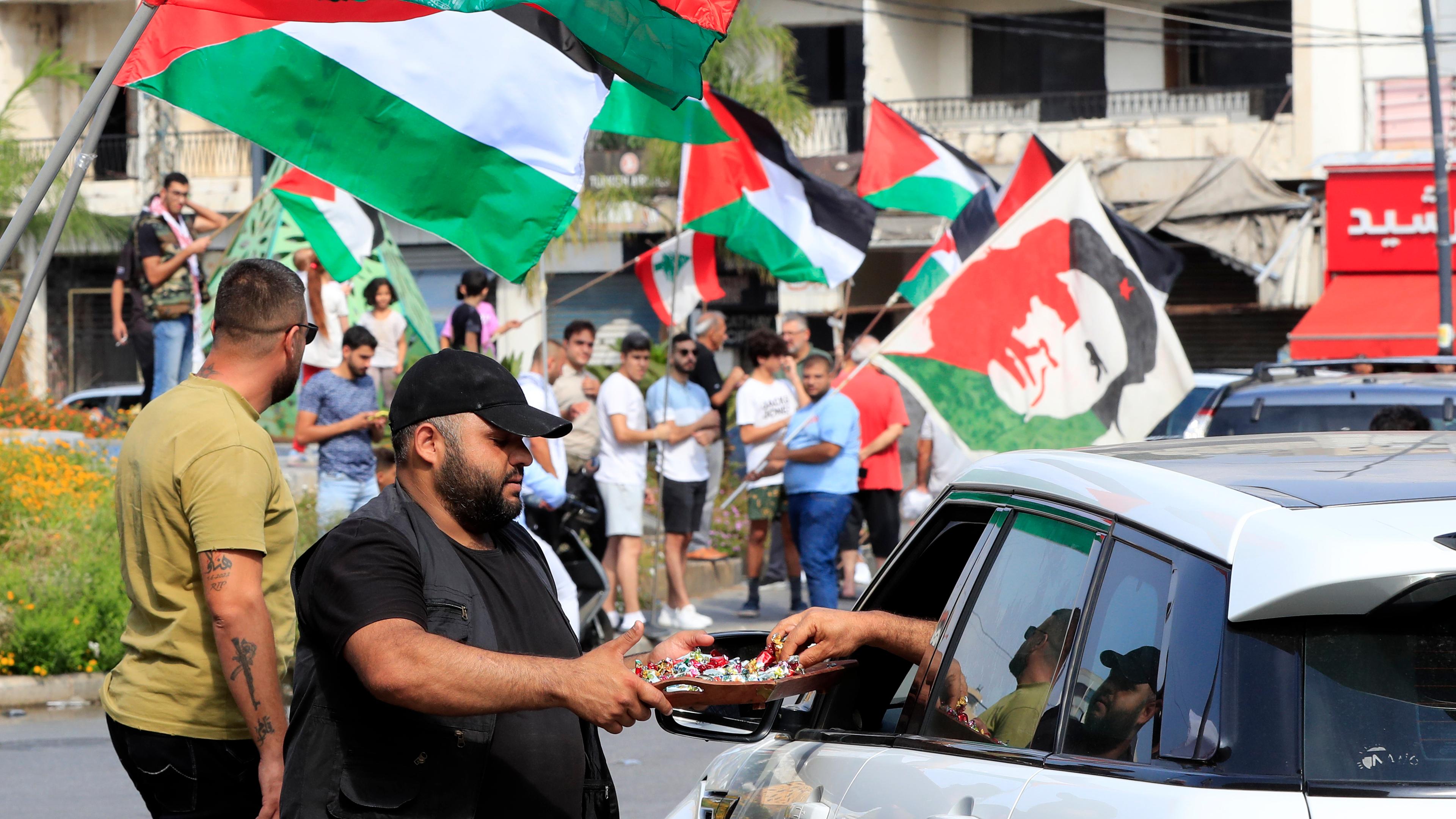 07.10.2023, Libanon, Sidon: Ein Mann verteilt in der südlichen Hafenstadt Süßigkeiten zur Feier der Angriffe, die die militante Hamas-Gruppe gegen Israel durchgeführt hat. 