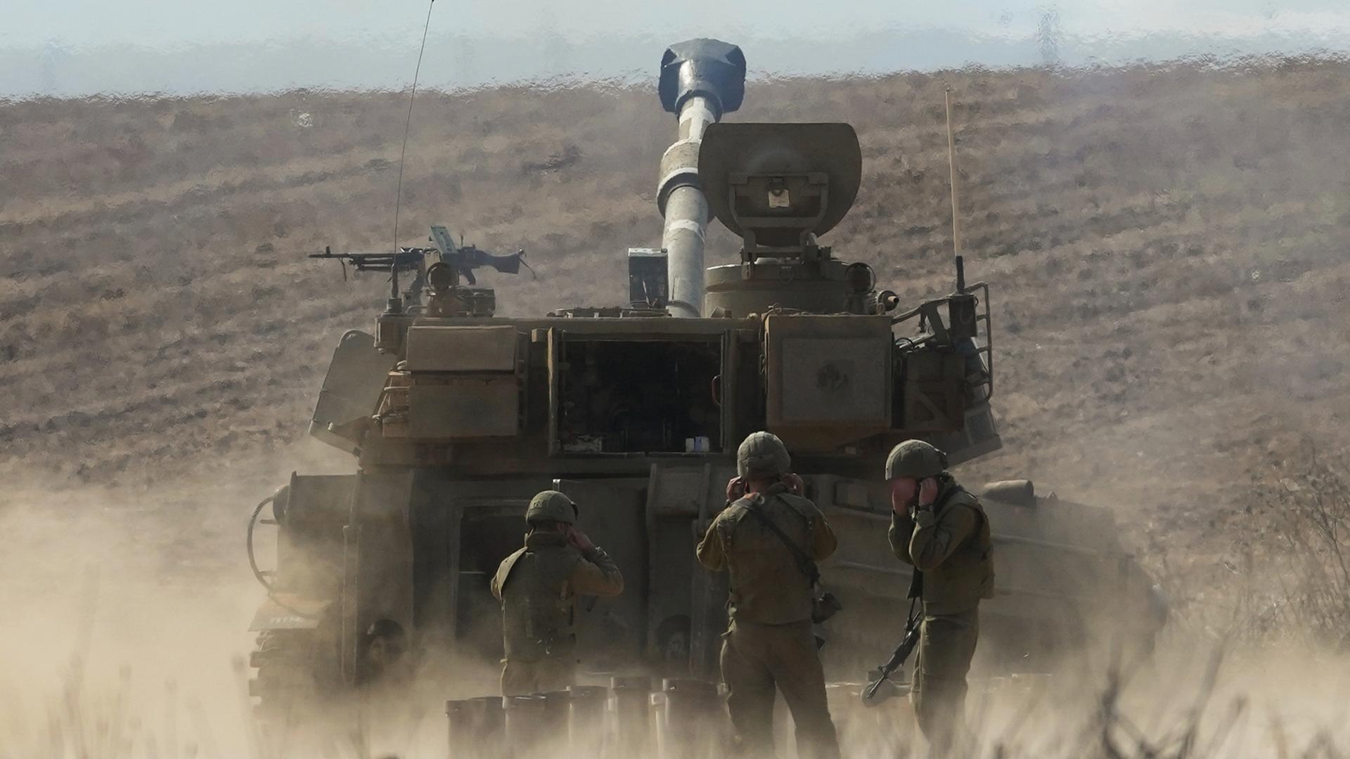Das Israelische Militär bereitet sich offenbar auf eine Bodenoffensive vor. Vier Soldaten stehen vor einem Panzer. Darüber die Schrift: "Was plant Israels Militär?"