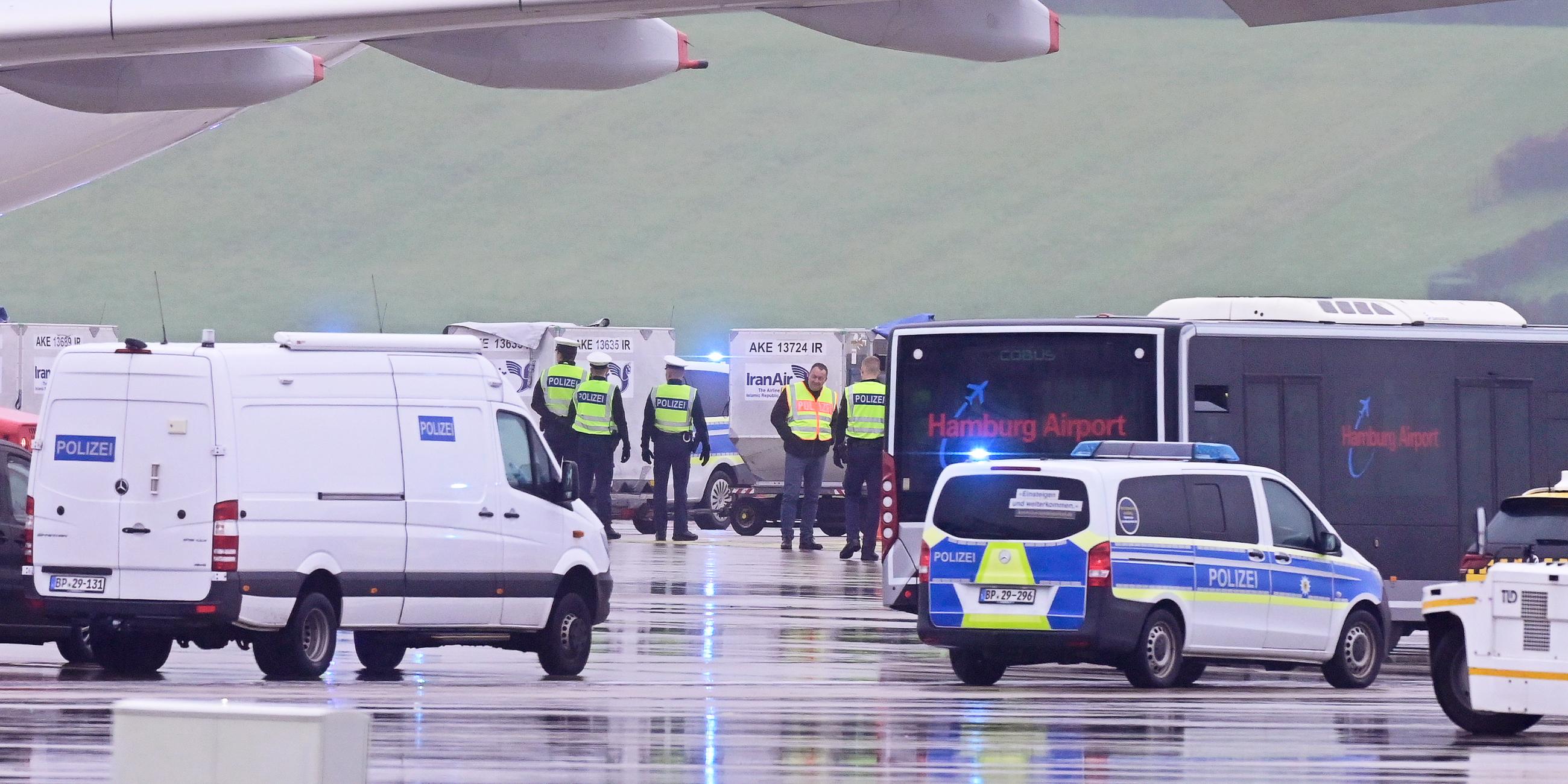 Einsatzfahrzeuge der Polizei stehen vor einem Flugzeug der Iran Air auf dem Flughafen Hamburg.