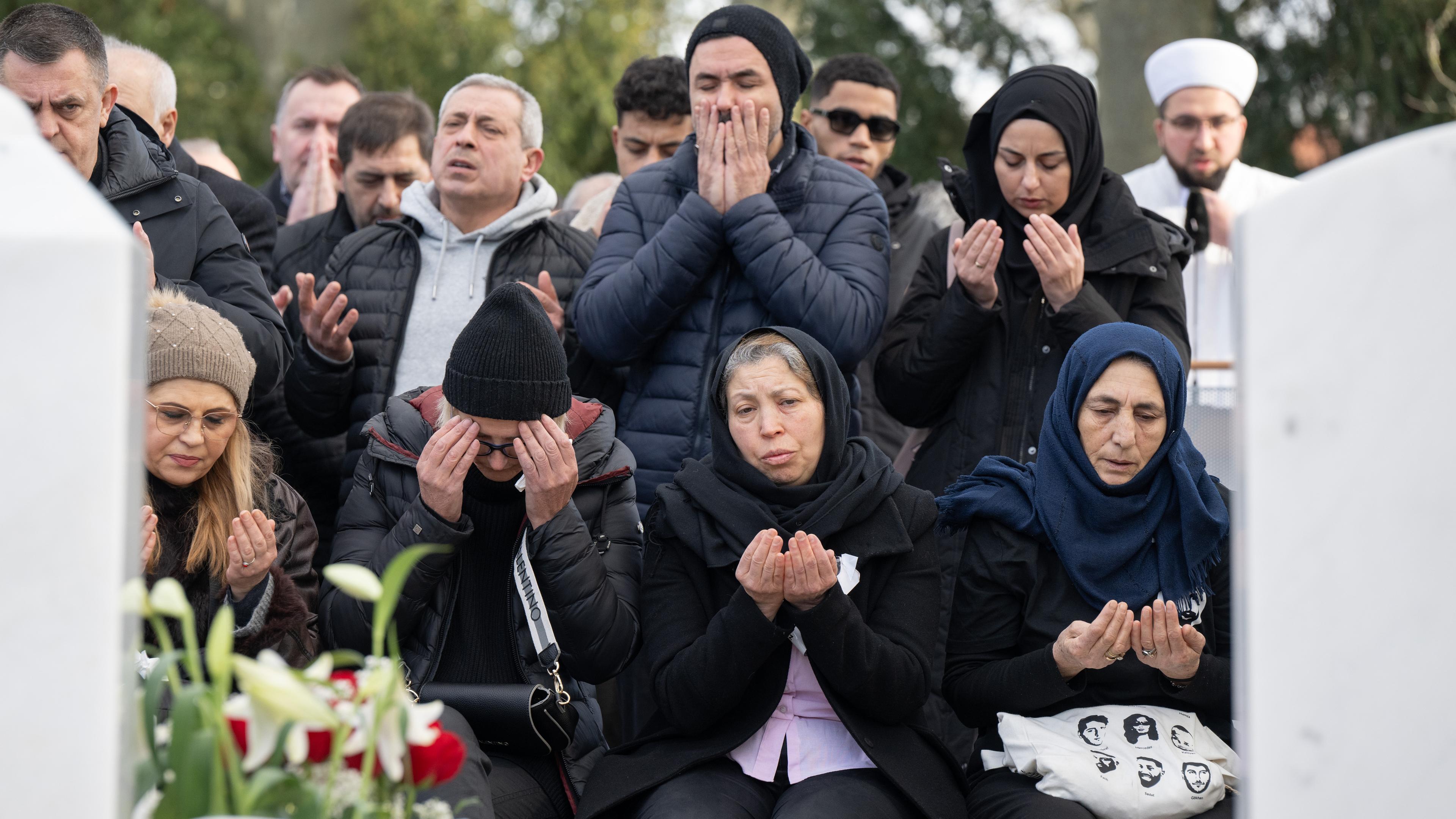 Hessen, Hanau: Angehörige und Freunde der Opfer gedenken an der Gräbern auf dem muslimischen Gräberfeld auf dem Hauptfriedhof in Hanau der Opfer des rassistischen Anschlags.