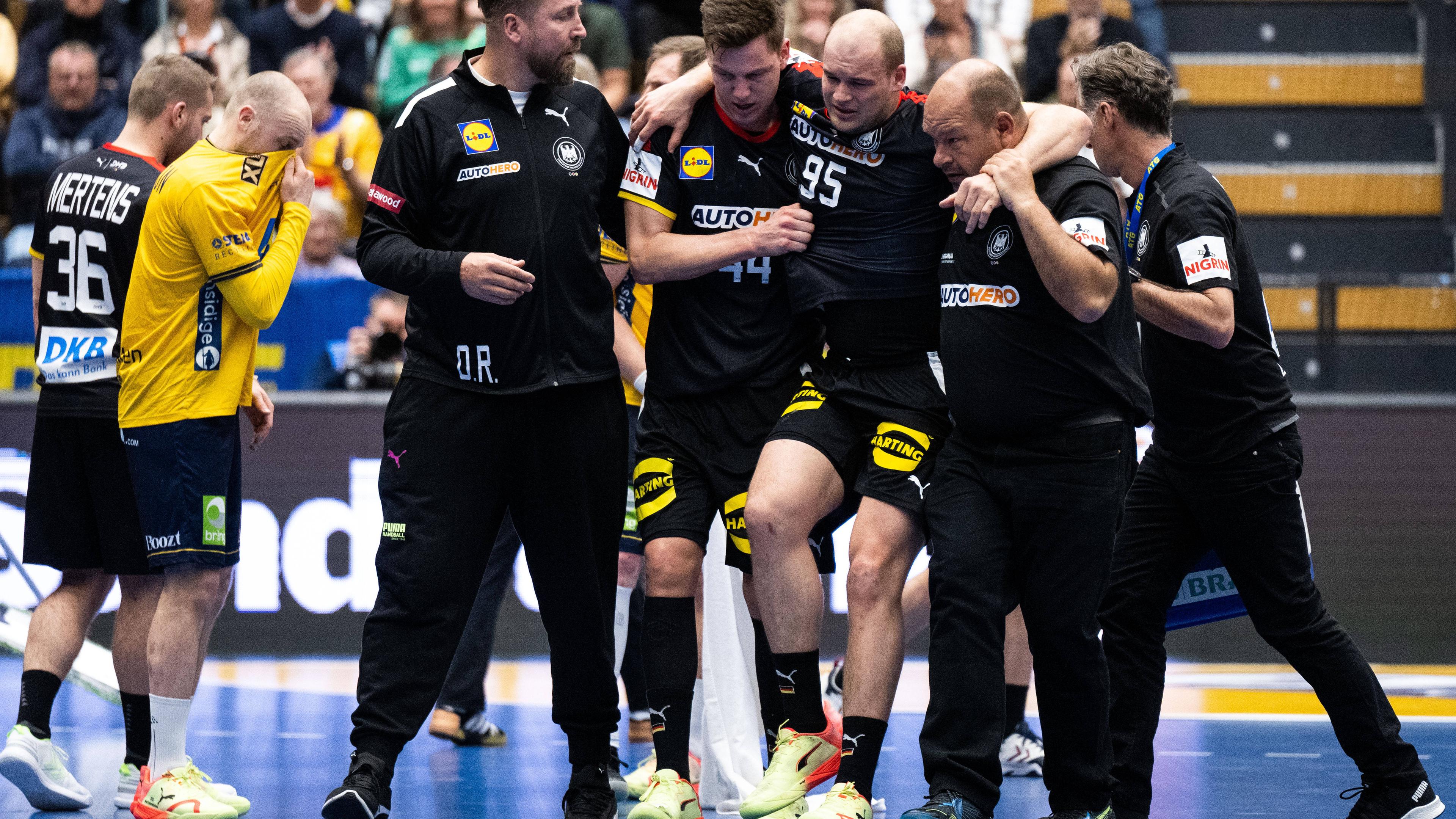 Paul Drux (mitte) wird im Handball-Testpiel Schweden - Deutschland am 27.4.2023 in Kristianstad verletzt vom Feld geführt.