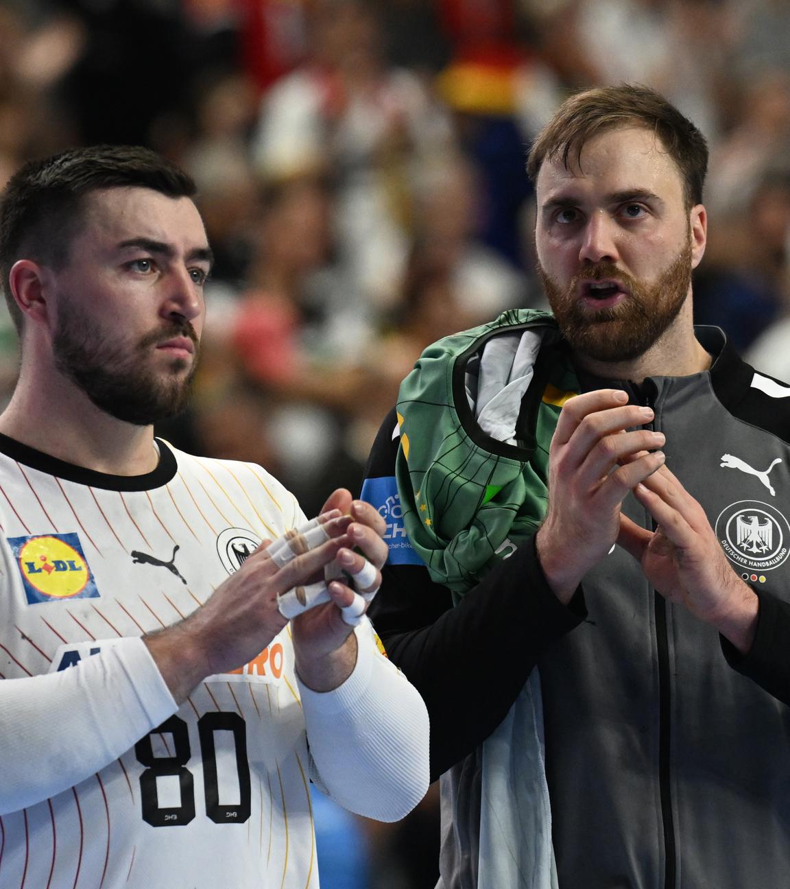 Handball-EM 2024, Schweden - Deutschland, Spiel um Platz 3: Jannik Kohlbacher und Deutschlands Torwart Andreas Wolff (rechts) applaudieren nach dem Spiel.
