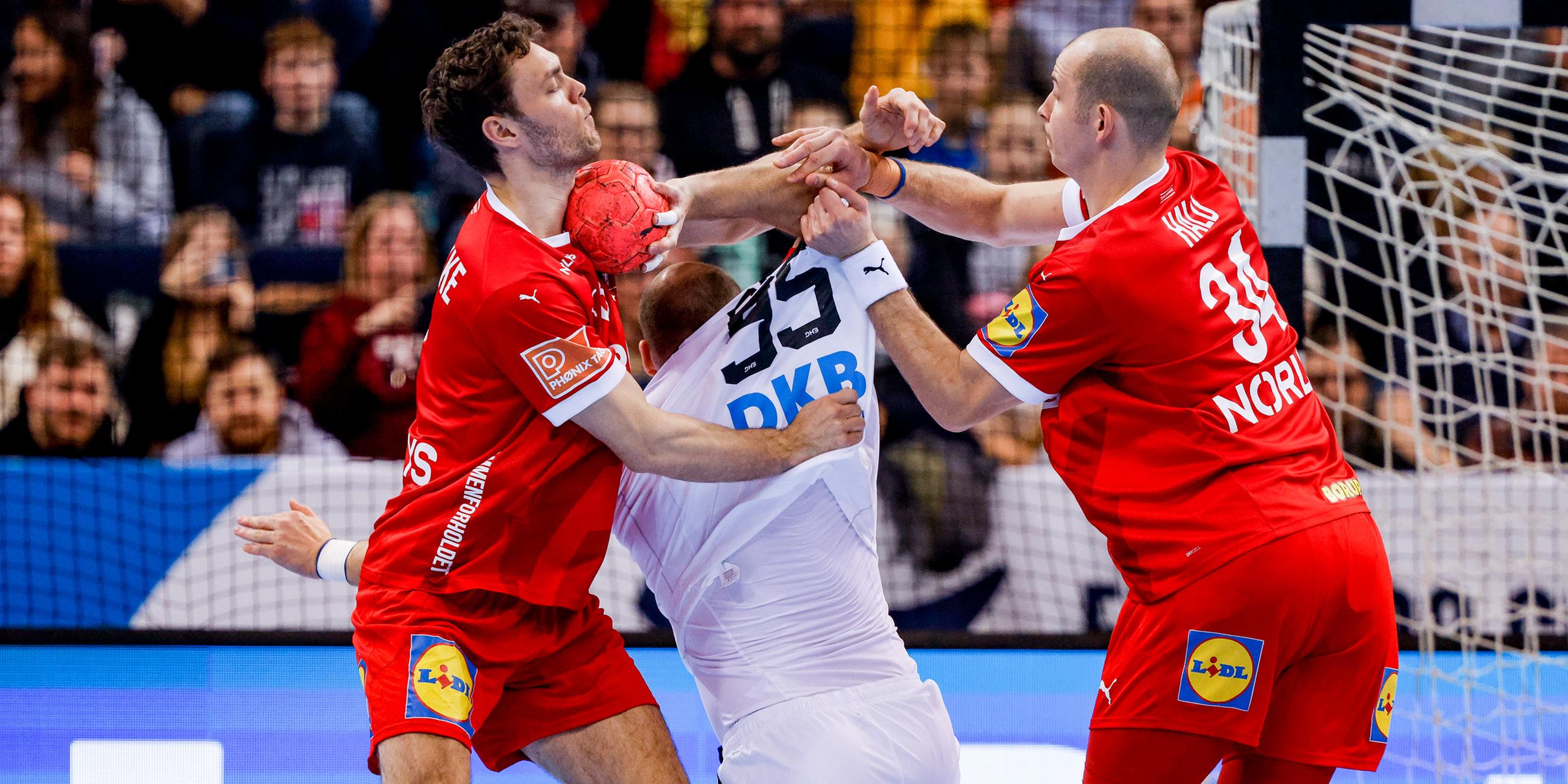 Dänemarks Niklas Kirkelokke (l-r), Deutschlands Paul Drux und Dänemarks Simon Hald Jensen kämpfen um den Ball.