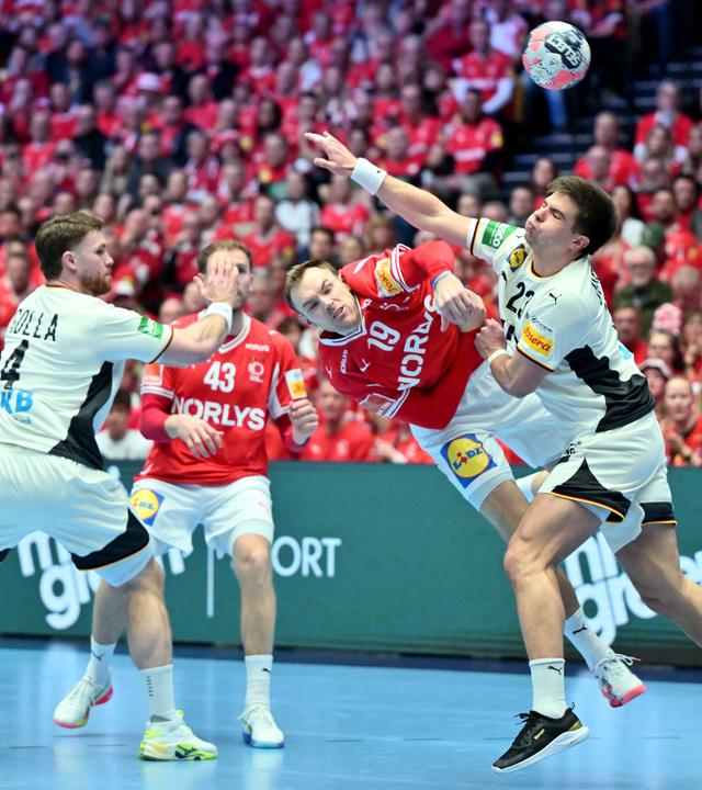 Dänemarks Mathias Gidsel setzt sich im Duell gegen Deutschlands Renars Uscins (r) durch.