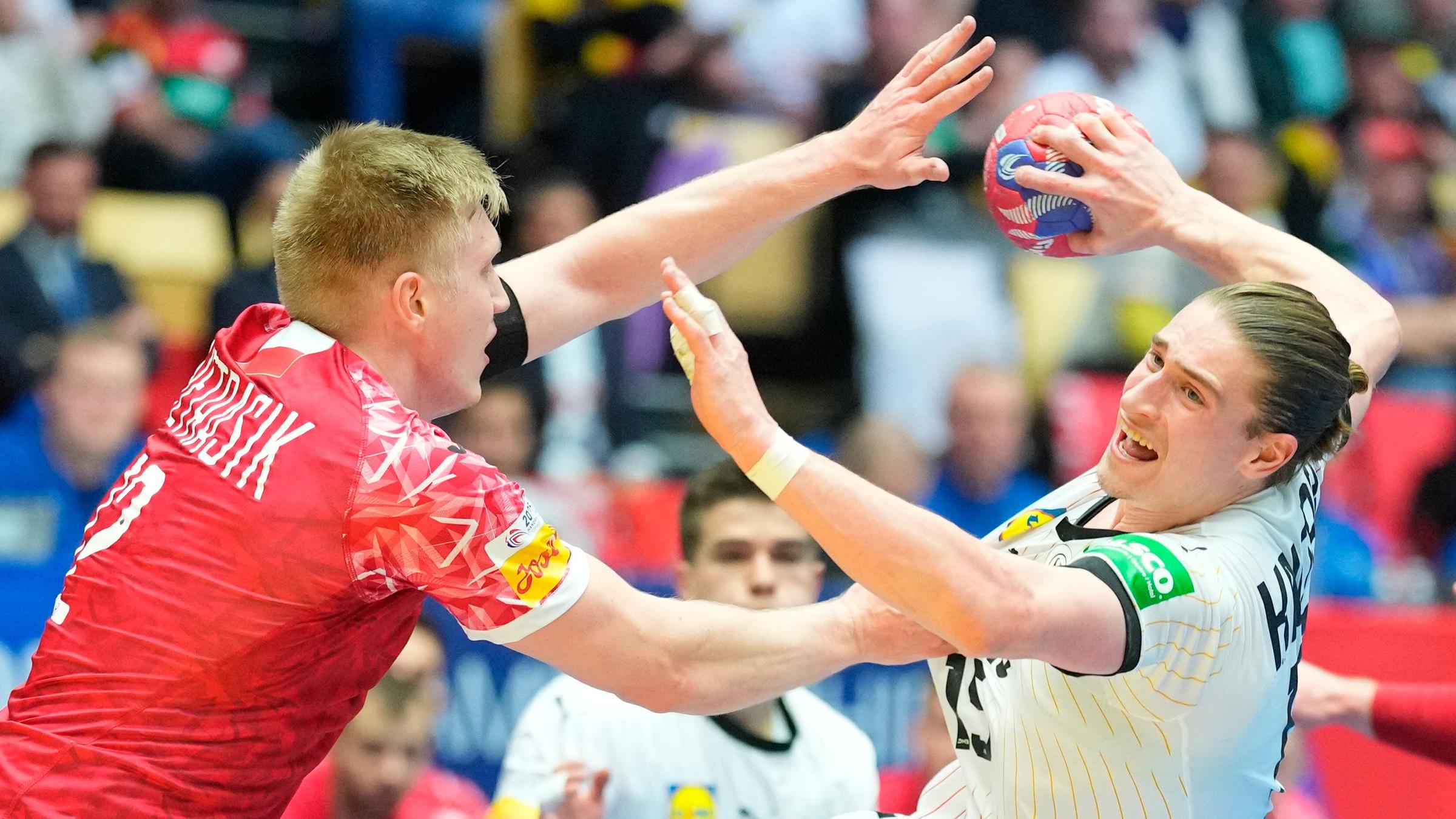 Deutschlands Juri Knorr und Polens Ariel Pietrasik kämpfen um den Ball beim Gruppenspiel der Handball-WM.