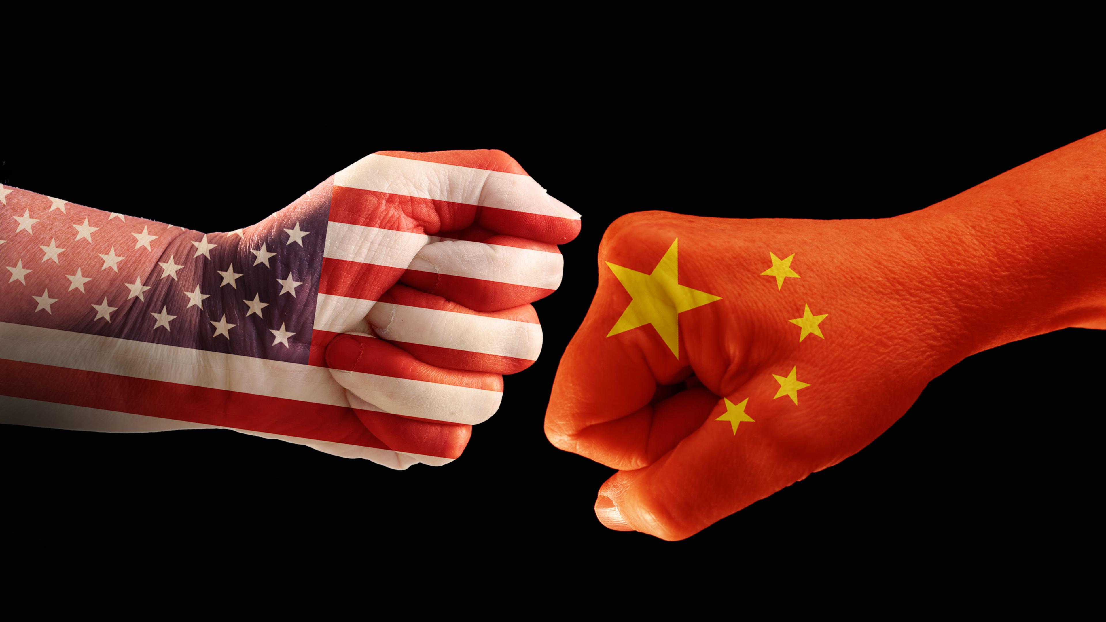  Zwei Fäuste in den Farben der Nationalflaggen von USA und China. Es ist ein Symbolbild für den Handelskrieg