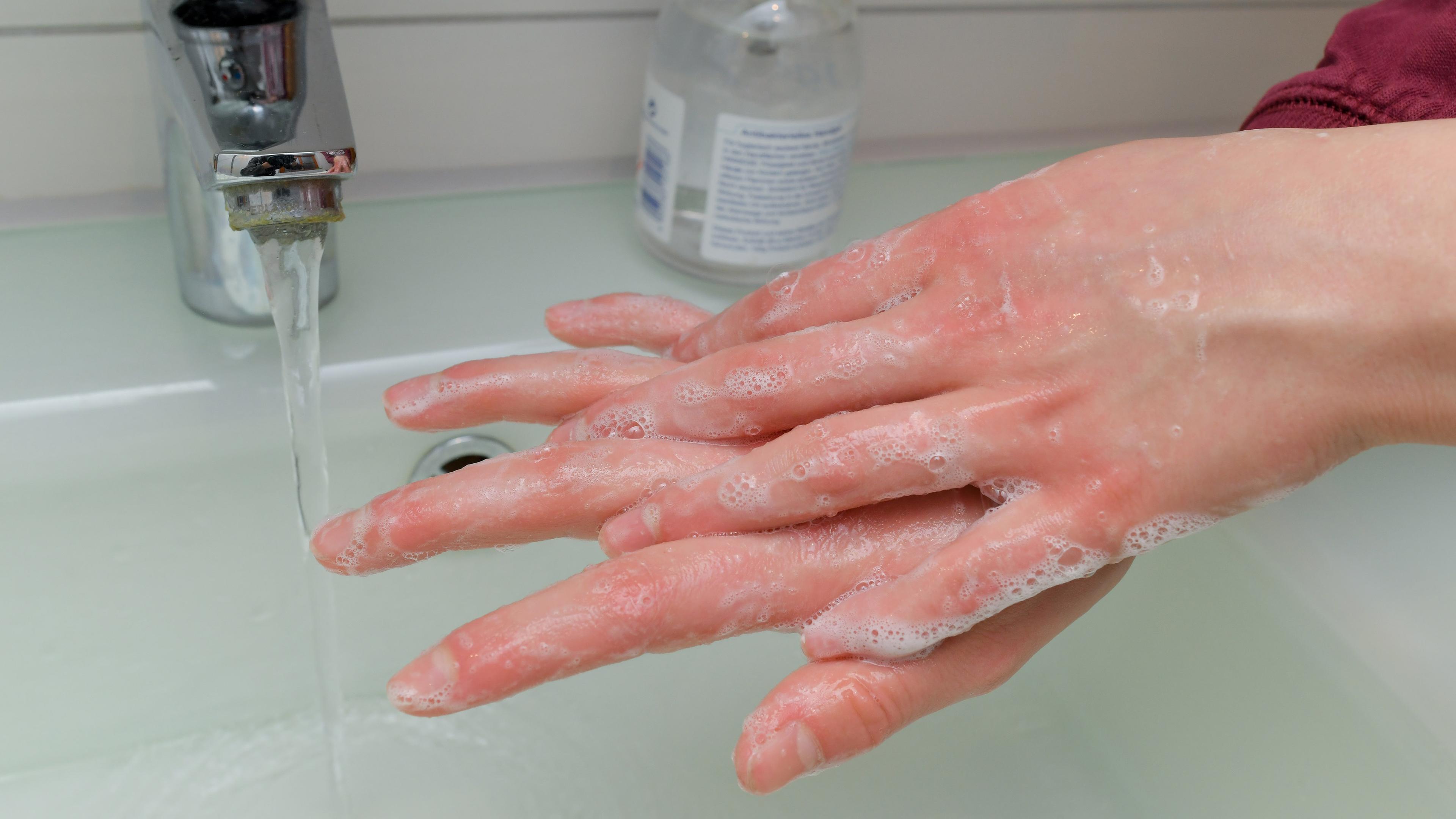 Archiv: Ein Mädchen wäscht sich die Hände mit Wasser und Seife.
