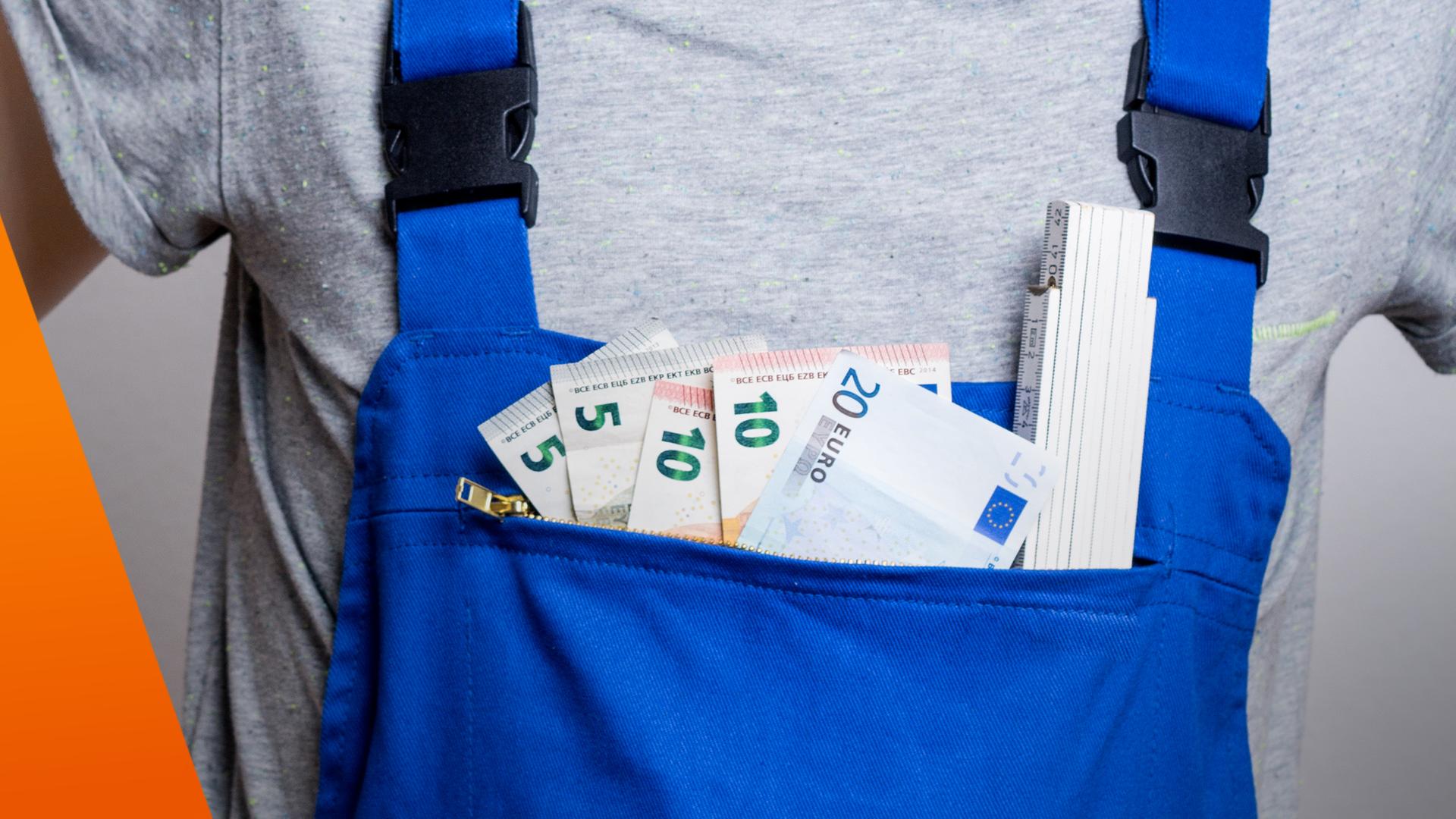 Handwerker mit Blaumann: In der Hosentasche stecken Geldscheine und ein Zollstock