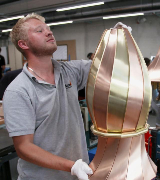 "Handwerker gesucht - Ein Berufsstand in der Krise": Ein junger Mann bearbeitet ein hohes, ovalförmiges Metallstück.