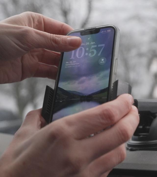 Jemand Steck Handy im Auto in eine Halterung