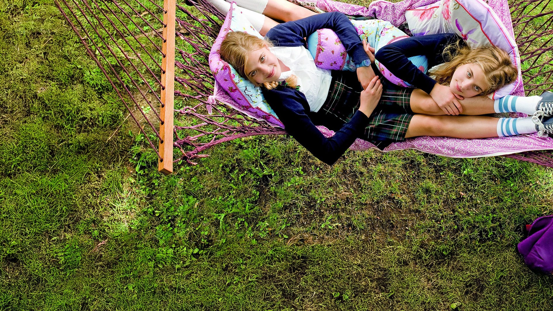 Die Zwillinge Hanni (Jana Münster) und Nanni (Sophia Münster) liegen gemeinsam in einer Hängematte und schauen in den Himmel.