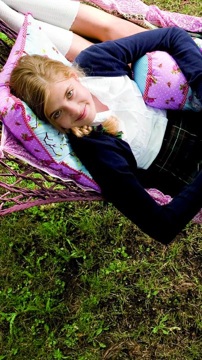 Die Zwillinge Hanni (Jana Münster) und Nanni (Sophia Münster) liegen gemeinsam in einer Hängematte und schauen in den Himmel.