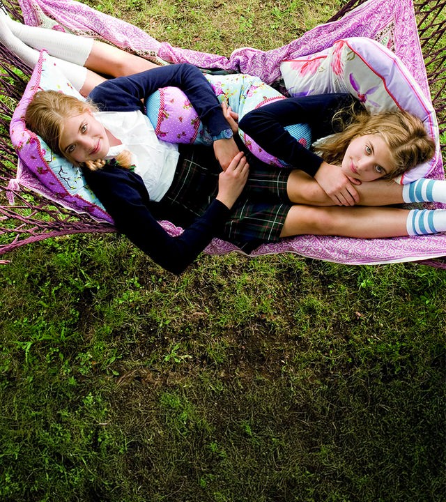 Die Zwillinge Hanni (Jana Münster) und Nanni (Sophia Münster) liegen gemeinsam in einer Hängematte und schauen in den Himmel.