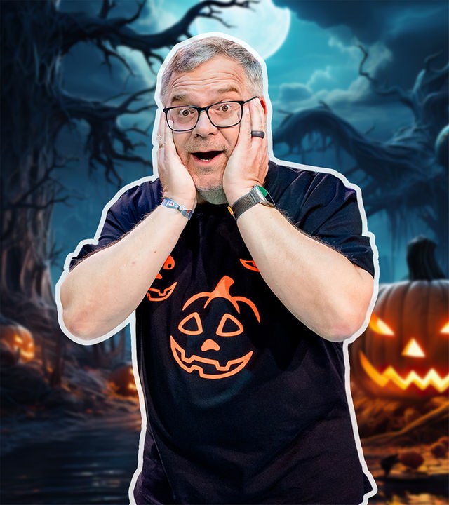 Elton schaut mit offenem Mund erschrocken in die Kamera. Hinter ihm zeigt die Halloween-Montage einen Nachthimmel und einen geschnitzten, leuchtenden Kürbis.