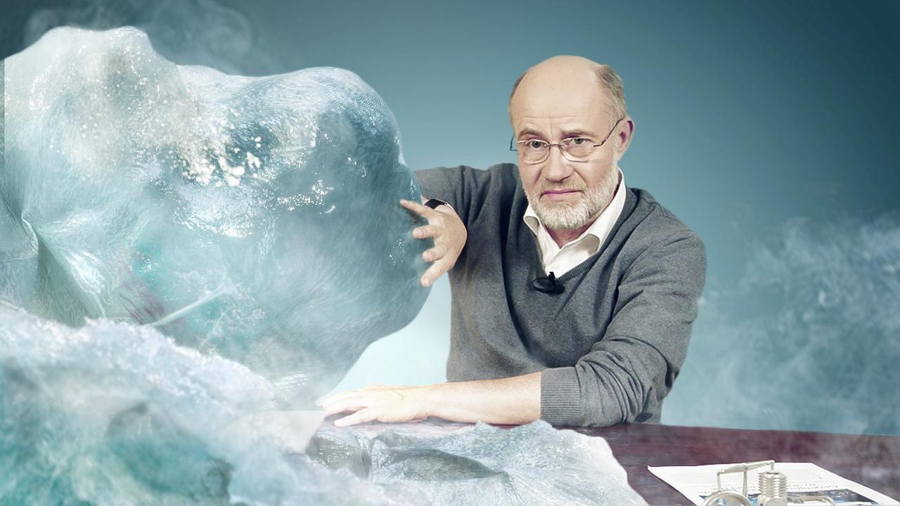 Harald Lesch schiebt eine Eisberg von seinem Schreibtisch