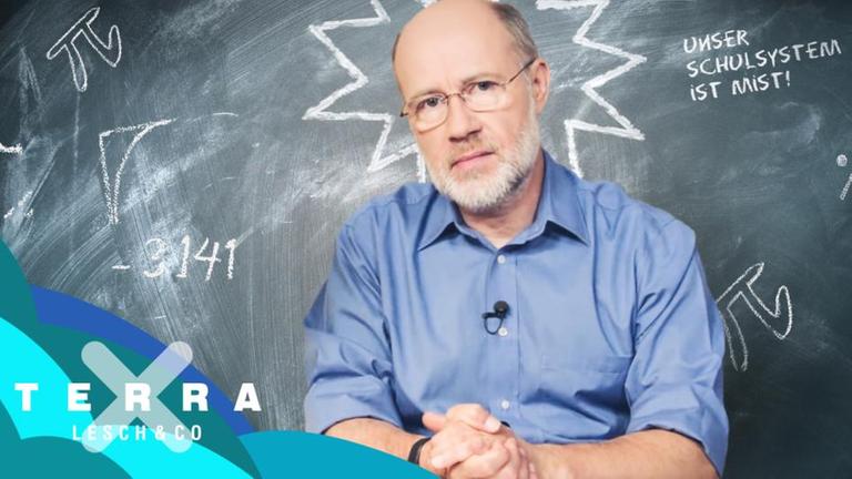 Harald Lesch vor beschriebener Schultafel