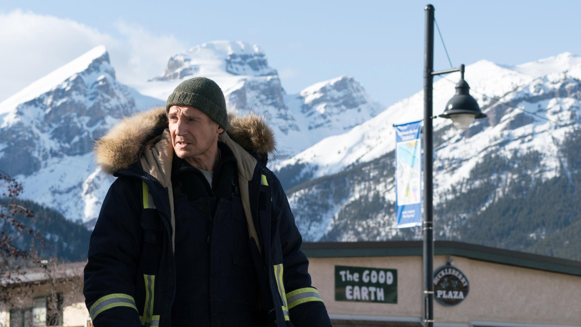 Nels Coxman (Liam Neeson) in Großaufnahme vor einem Bergpanorama.