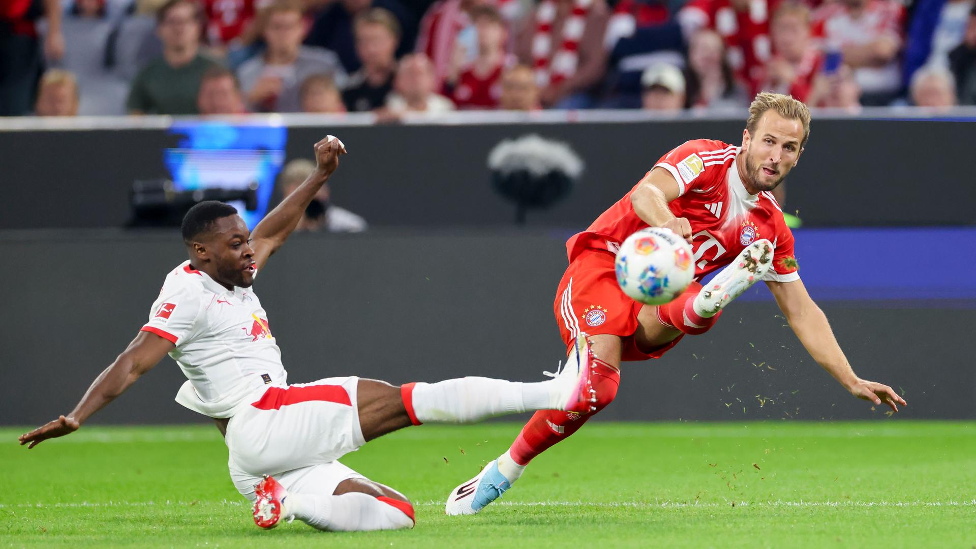 Ridle Baku (RB Leipzig) und Harry Kane (FC Bayern Muenchen) kaempfen um den Ball.